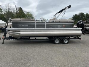 2025 Sun Tracker PARTY BARGE® 22 DLX pontoon boat on trailer, parked outdoors.