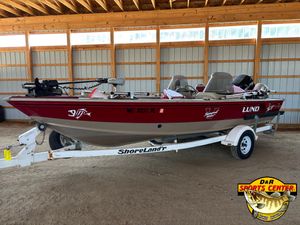 1997 Lund 1900 Pro-V LE fishing boat on ShoreLand'r trailer in a wooden storage shed.
