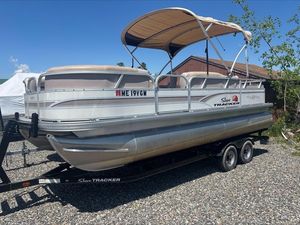2015 Sun Tracker PARTY BARGE® 22 DLX pontoon boat on trailer, parked outdoors.