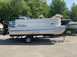 2026 Sun Tracker PB 16 DLX pontoon boat on trailer, parked outdoors.