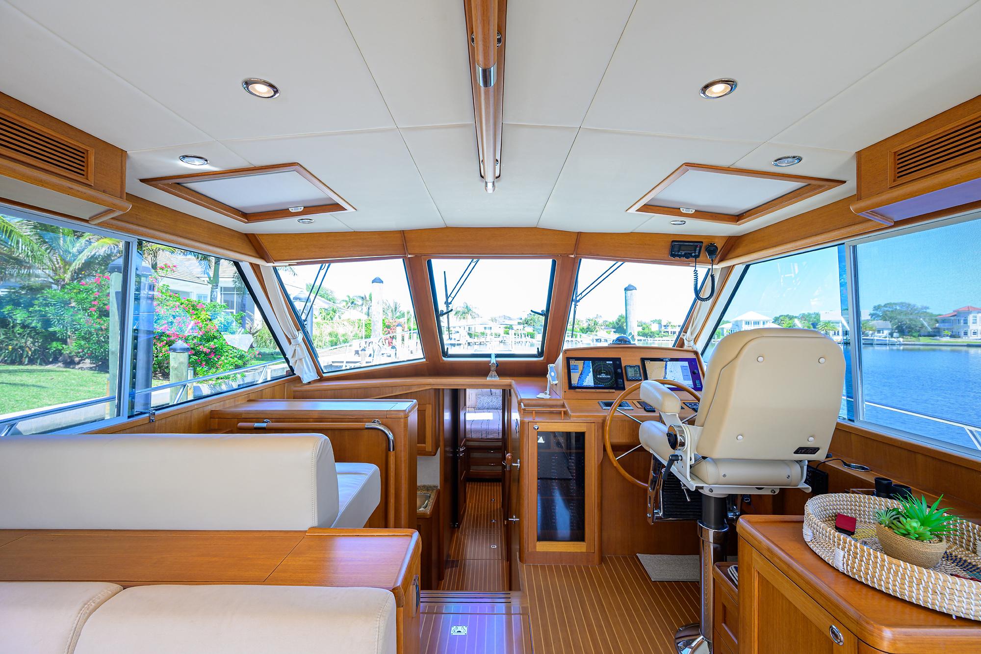 Luxurious interior of 2014 Grand Banks 46 Eastbay SX yacht with panoramic windows and elegant seating.