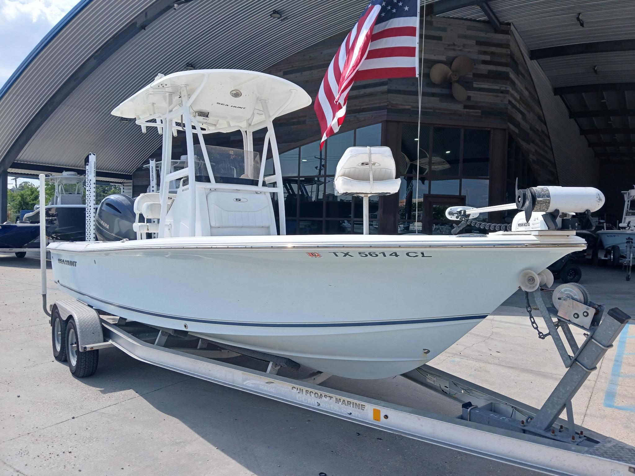 2014 Sea Hunt BX 22 BR boat on trailer, American flag, parked at marina.