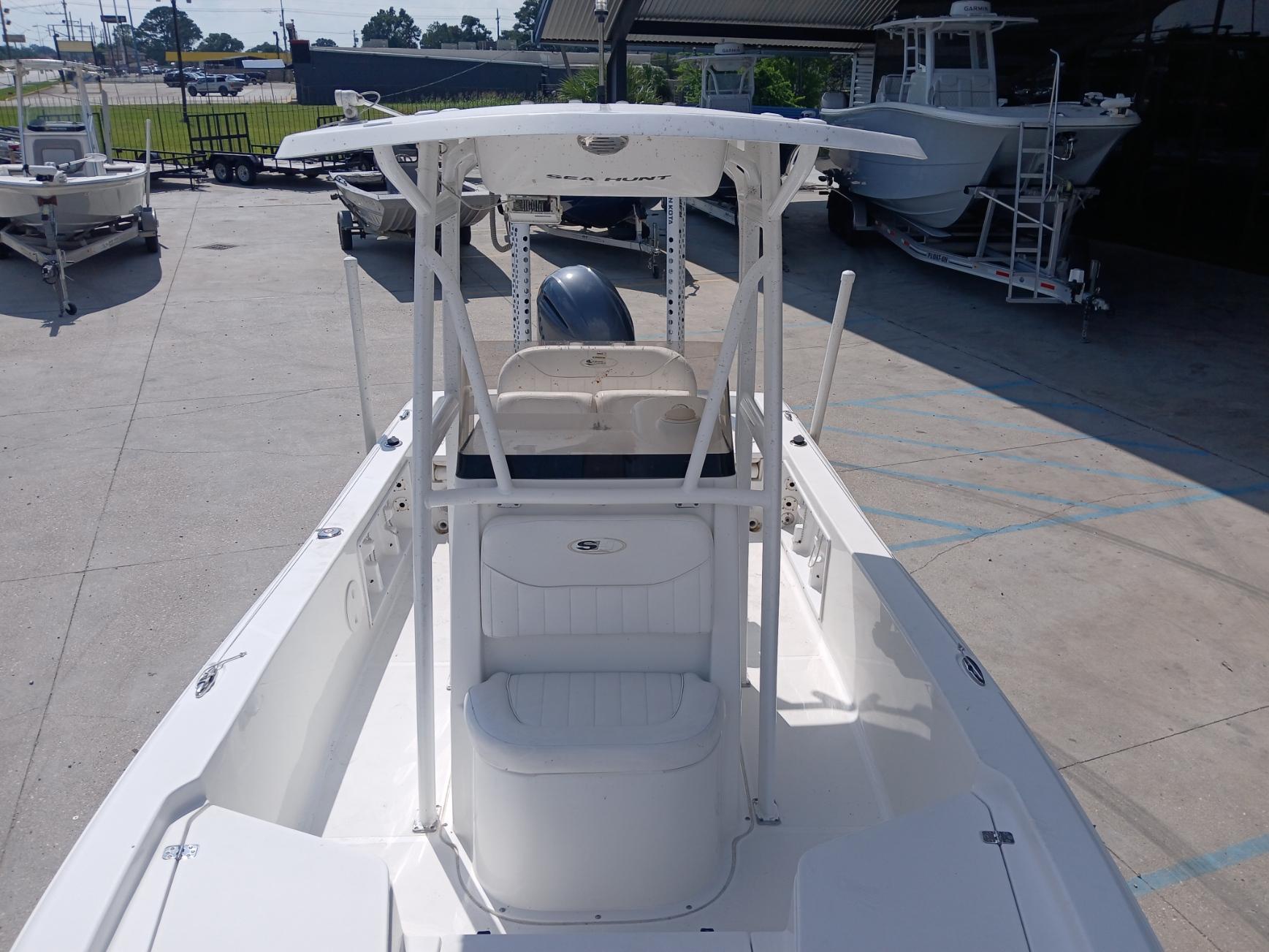 2014 Sea Hunt BX 22 BR boat with T-top, parked in a marina.