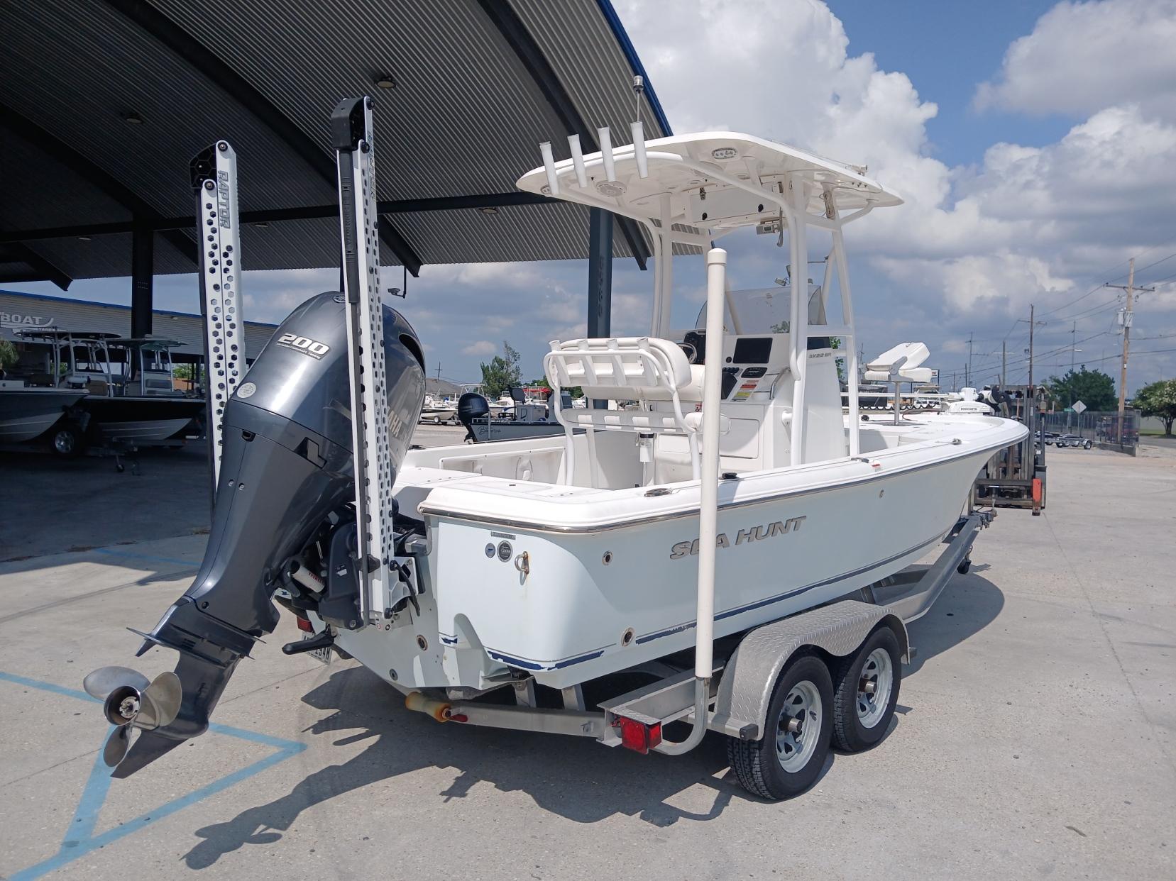 2014 Sea Hunt BX 22 BR boat on trailer, parked outdoors under a canopy.