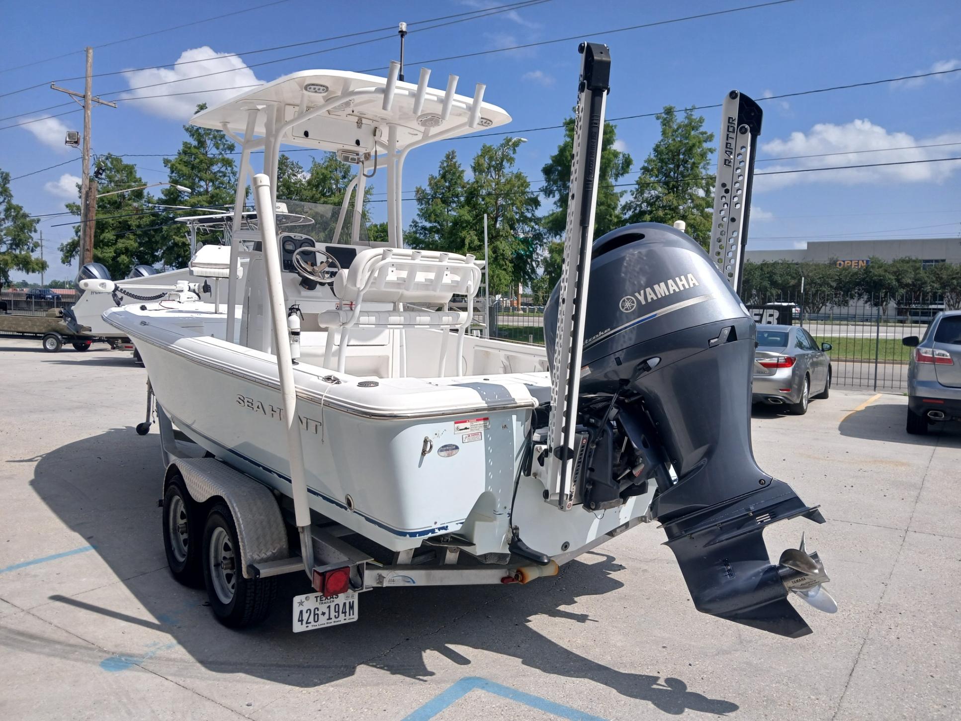 2014 Sea Hunt BX 22 BR boat with Yamaha motor on trailer in parking lot.
