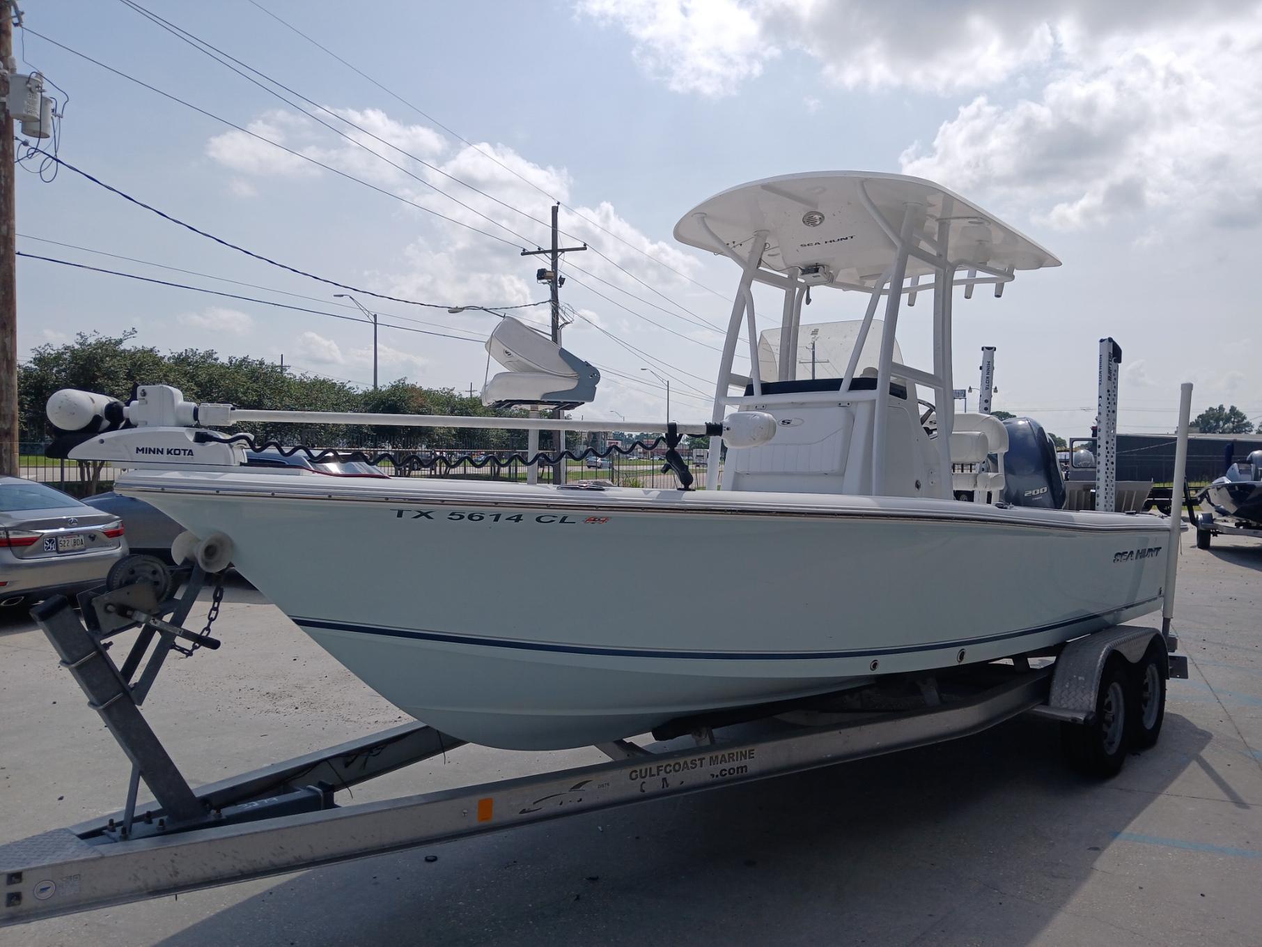 2014 Sea Hunt BX 22 BR boat on trailer, parked outdoors under cloudy sky.