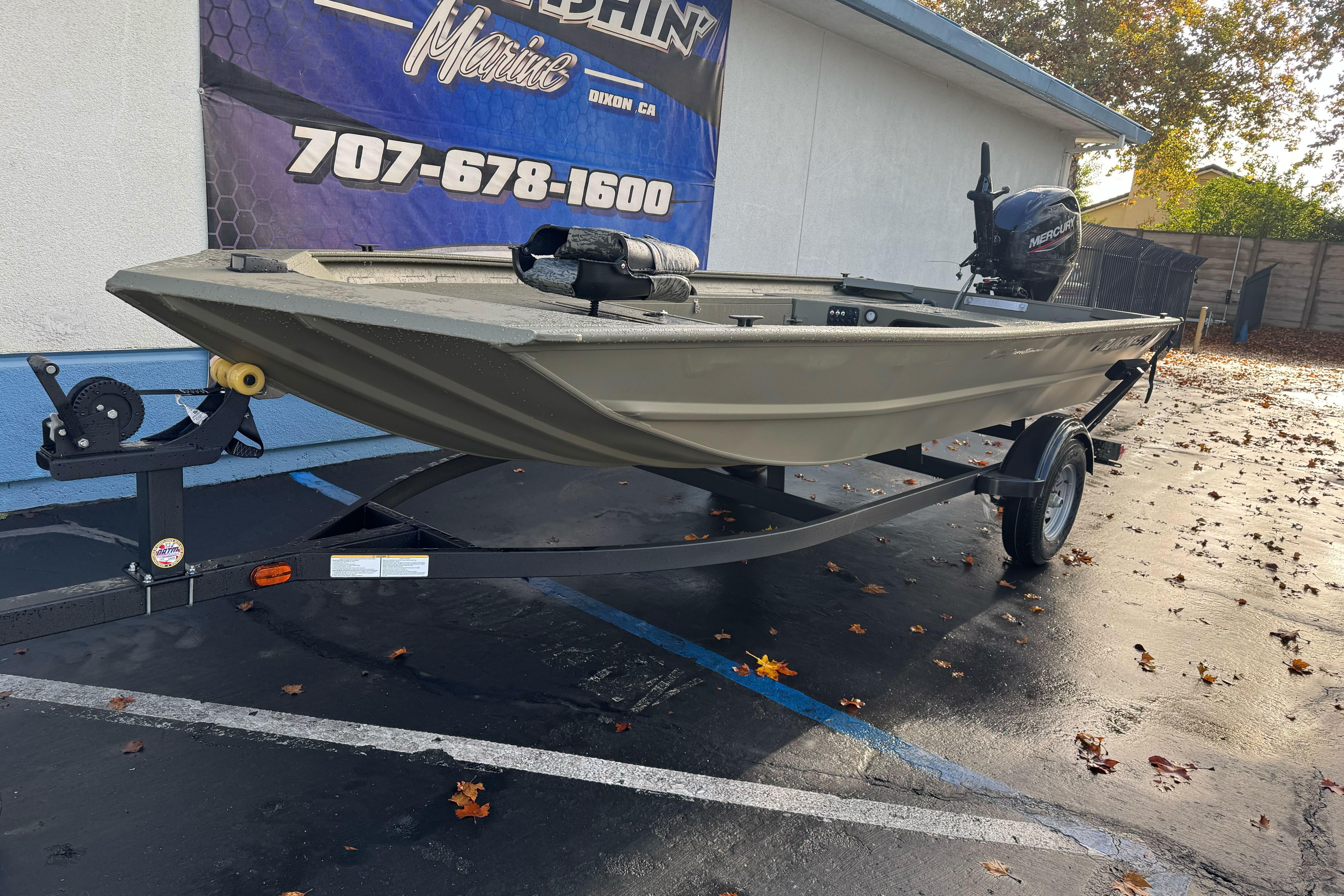 2026 Tracker Grizzly 1654 T Sportsman boat on trailer, parked outdoors.