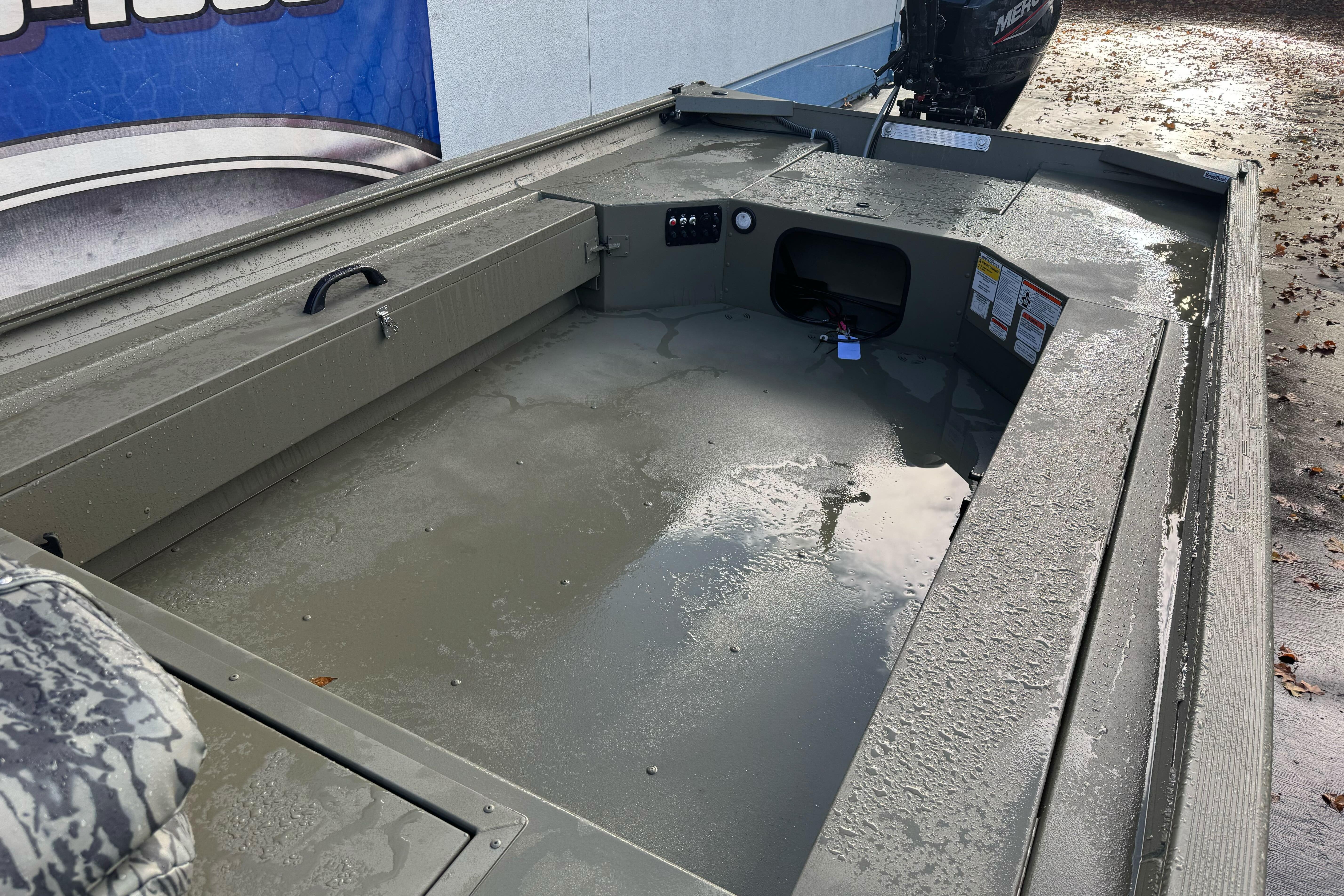 2026 Tracker Grizzly 1654 T Sportsman boat interior with wet floor and motor.