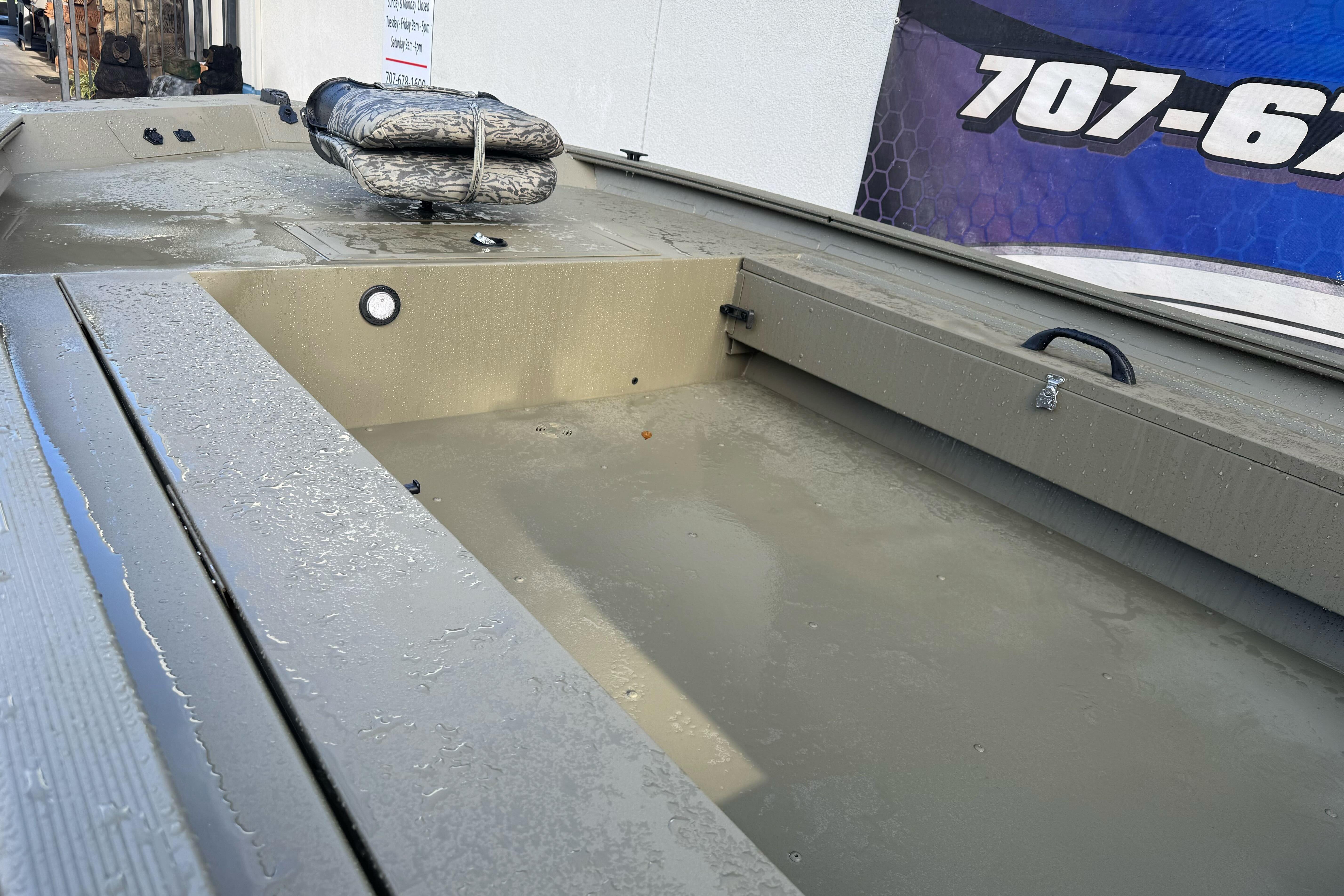 2026 Tracker Grizzly 1654 T Sportsman boat interior with storage compartments and camo seat.