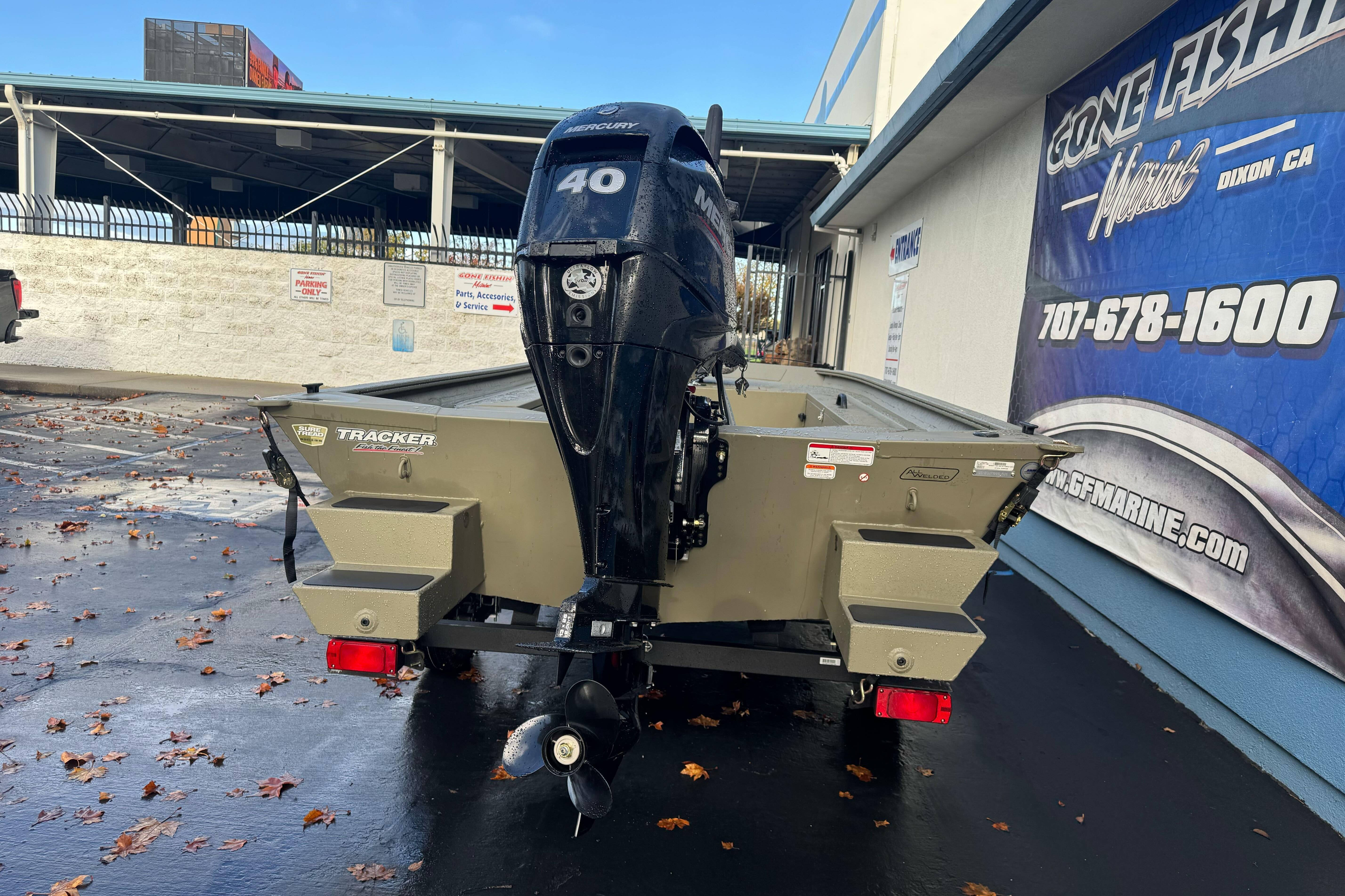 2026 Tracker Grizzly 1654 T Sportsman boat with Mercury 40 outboard motor, parked outdoors.