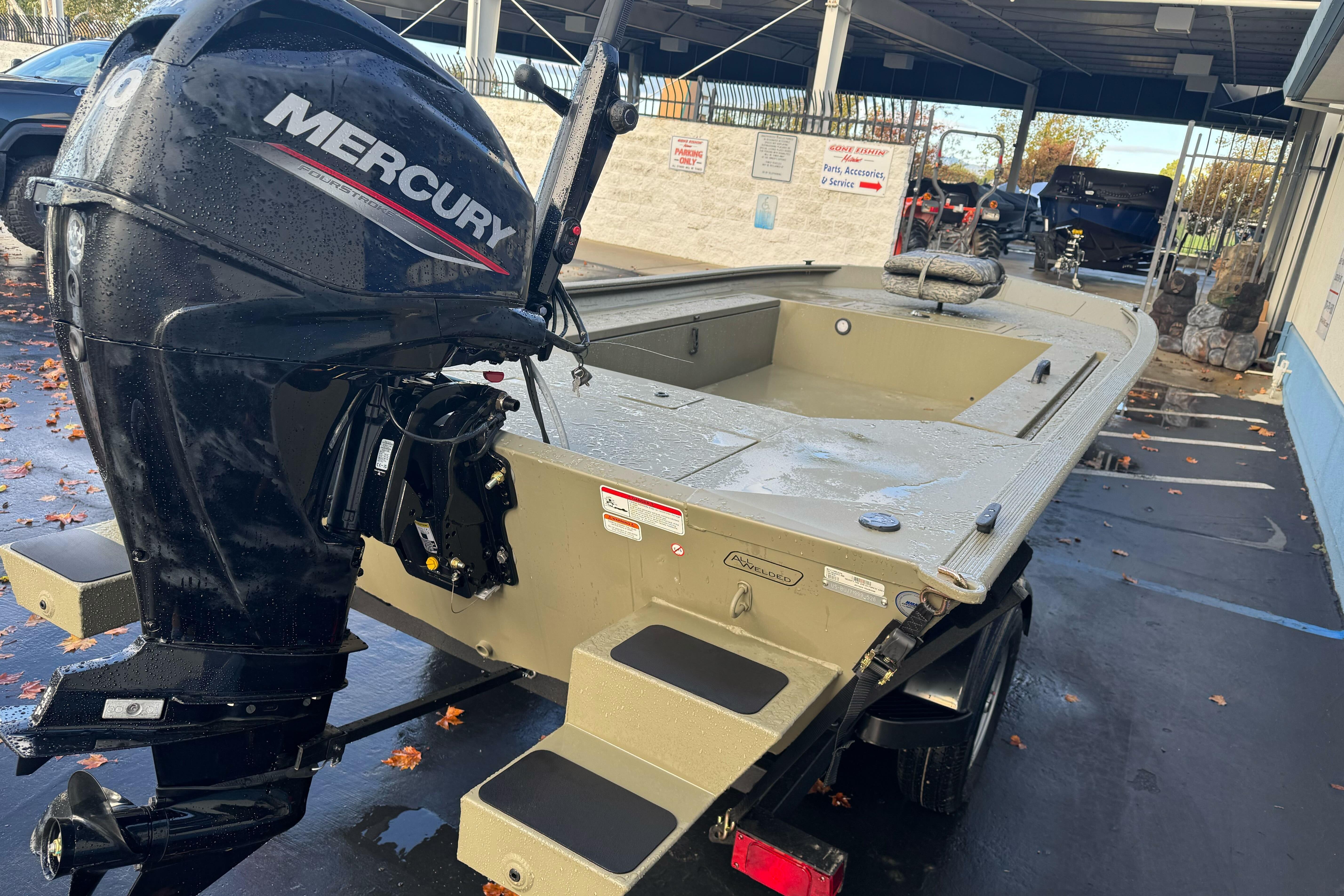 2026 Tracker Grizzly 1654 T Sportsman boat with Mercury outboard motor, parked outdoors.