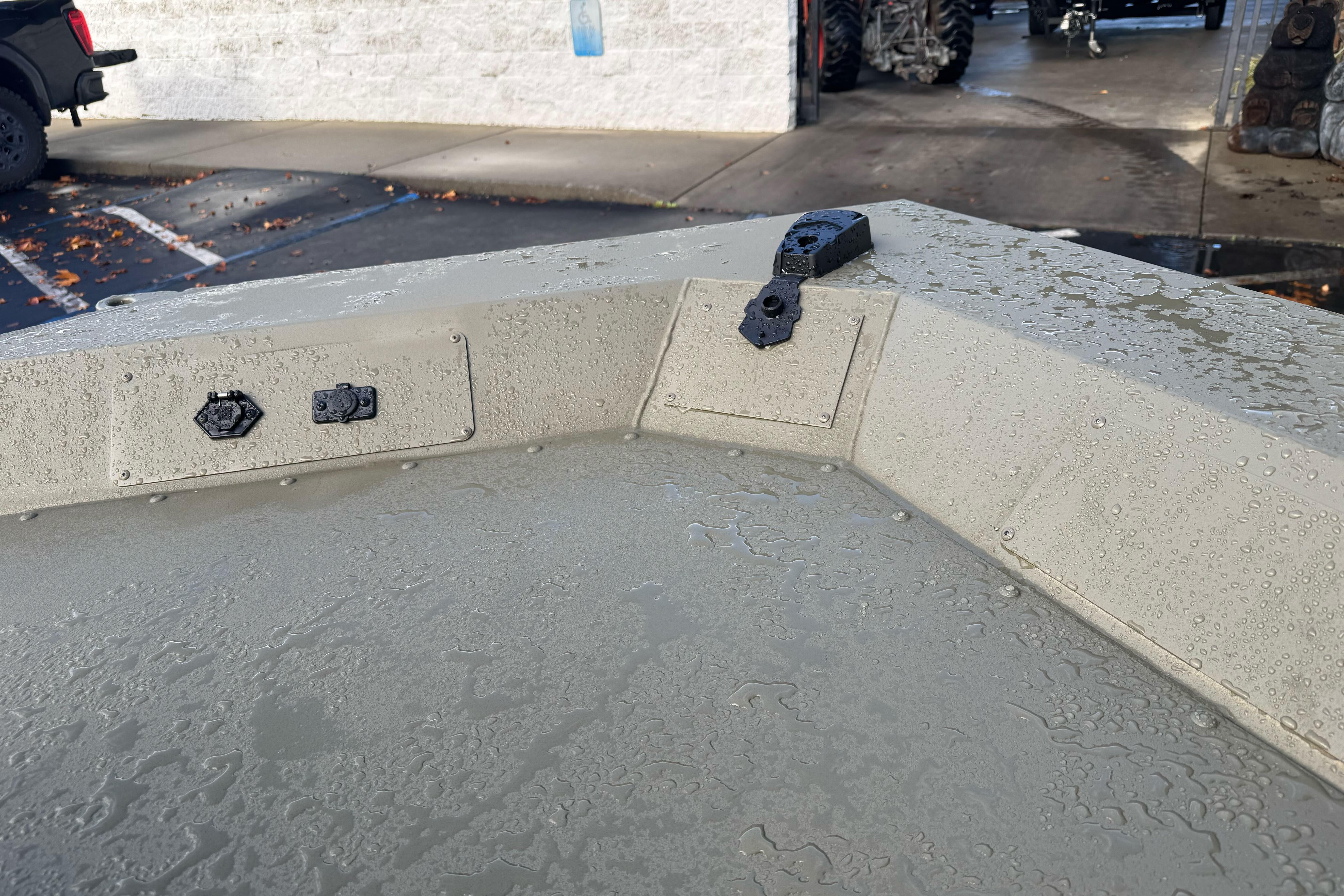 2026 Tracker Grizzly 1654 T Sportsman boat with water droplets on surface.