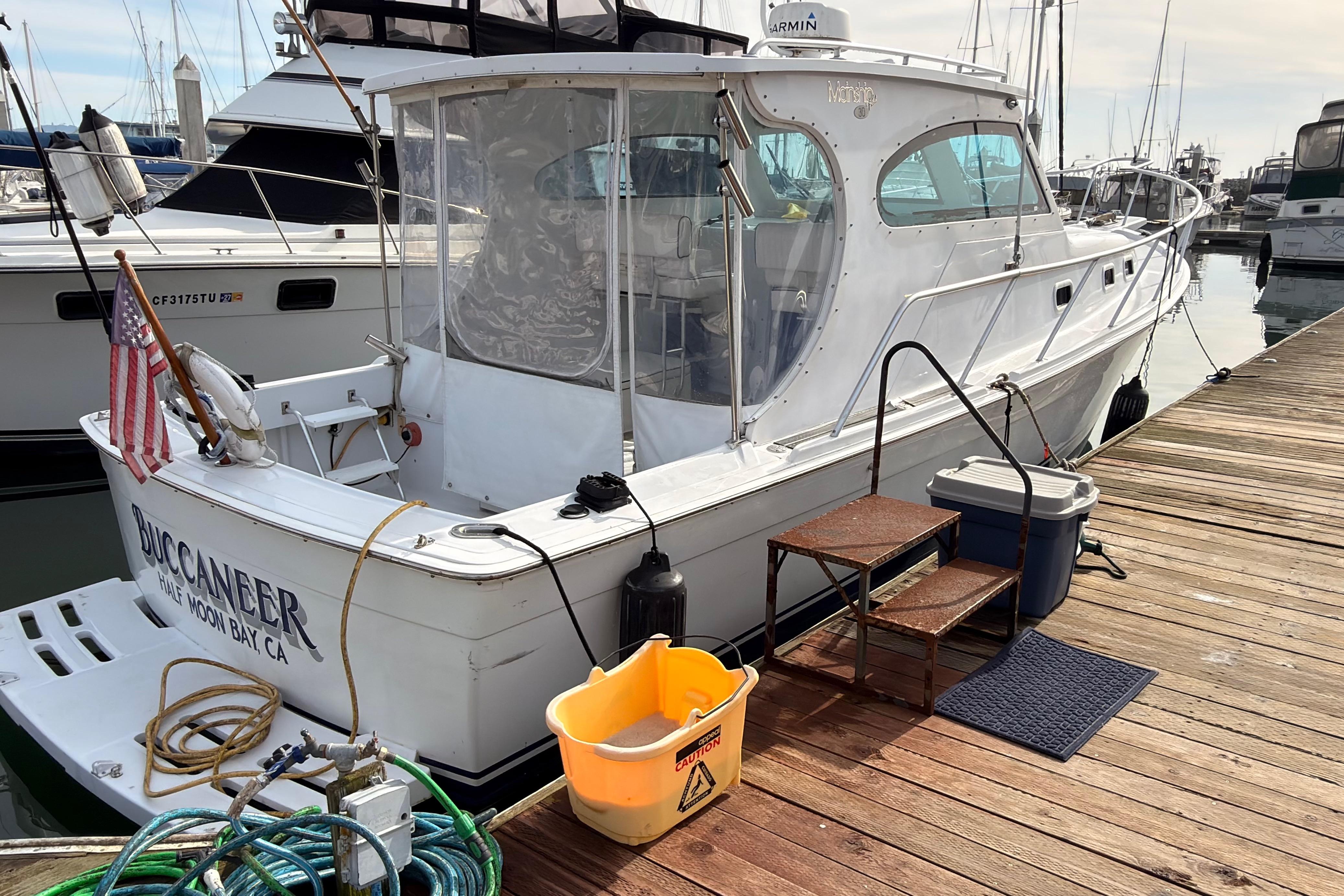 1999 Mainship Pilot 30 docked at marina, labeled "Buccaneer," Half Moon Bay, CA.