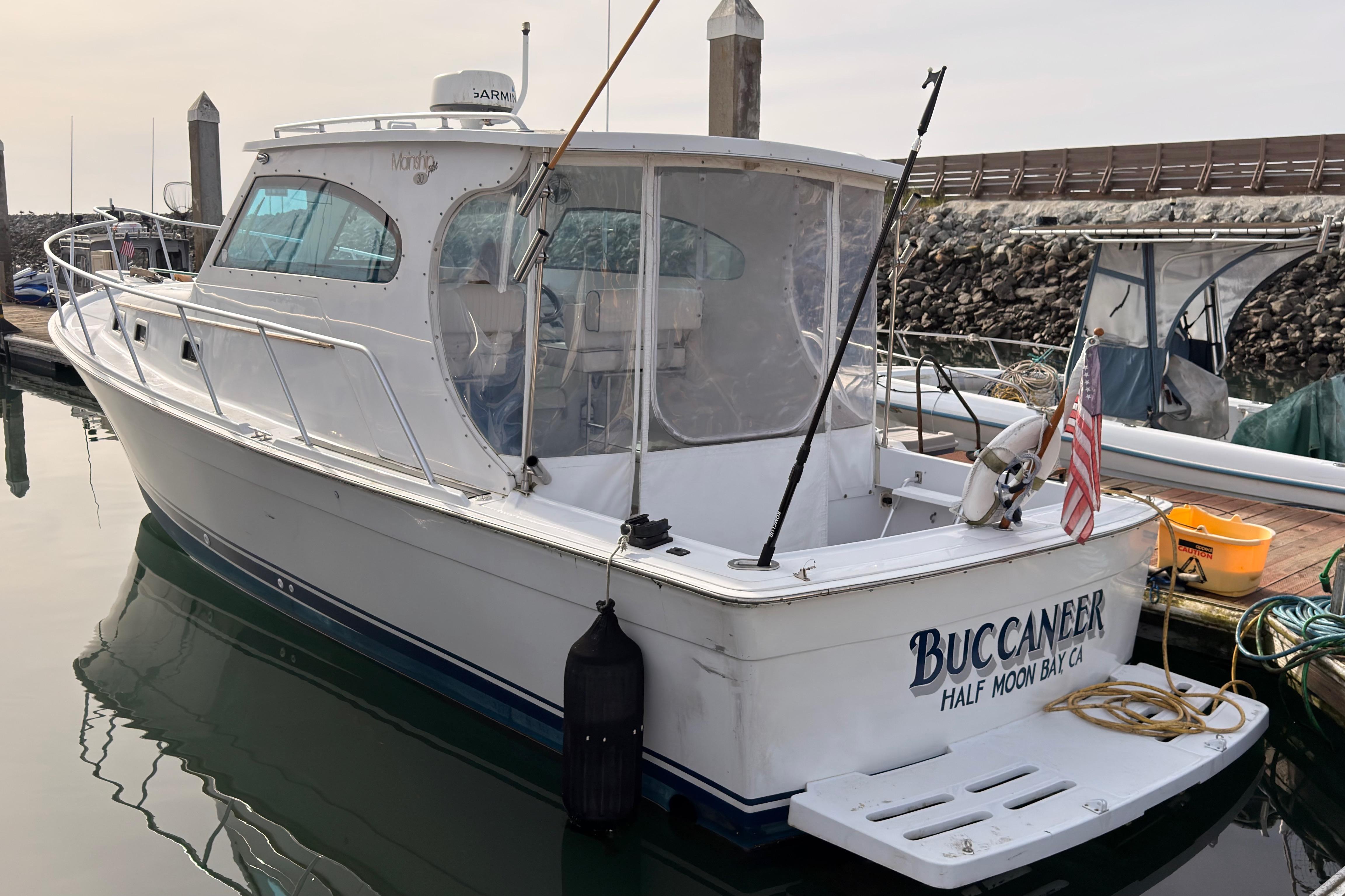 1999 Mainship Pilot 30 boat named "Buccaneer" docked at a marina.
