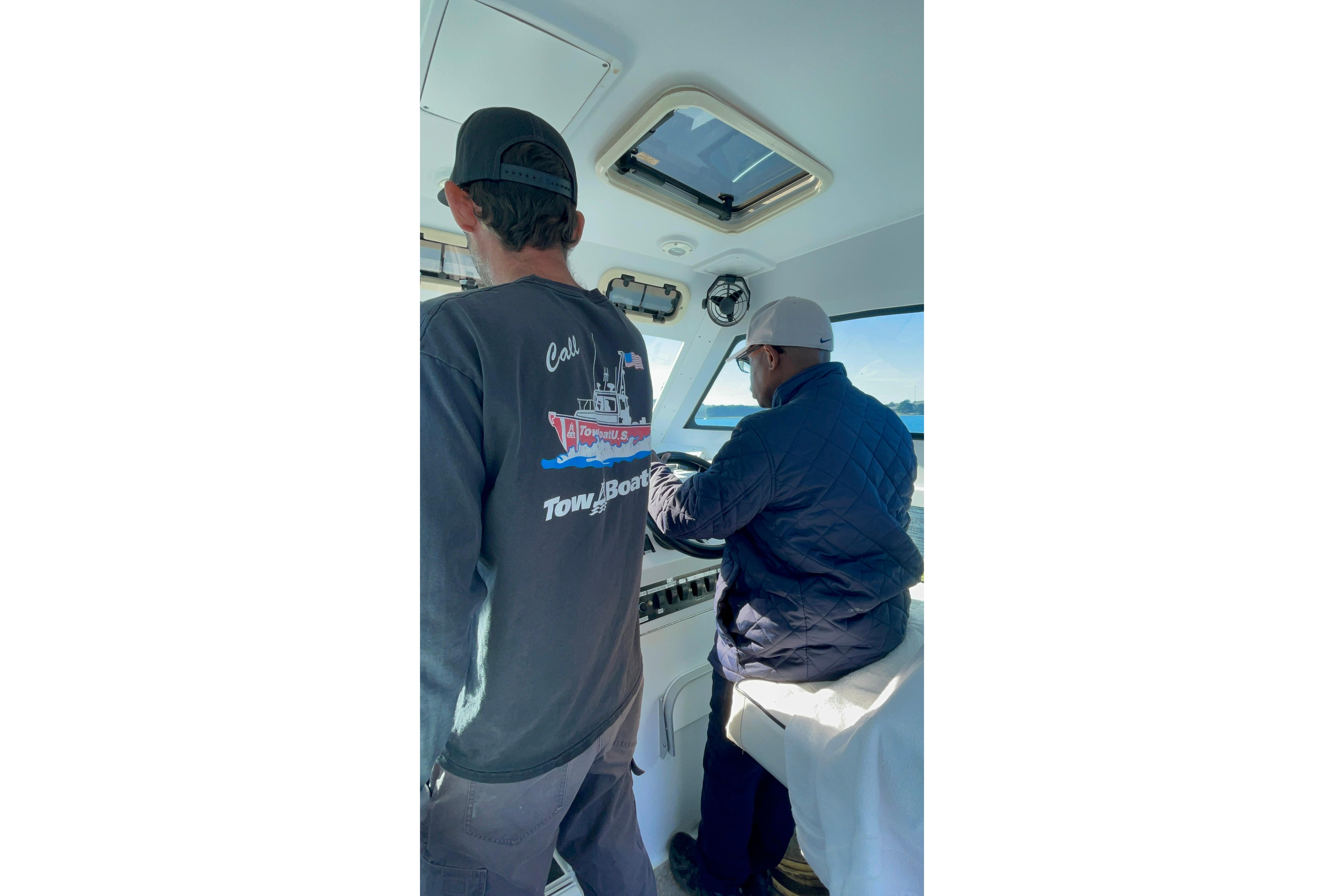 Two people navigating a 1999 Mainship Pilot 30 boat interior.