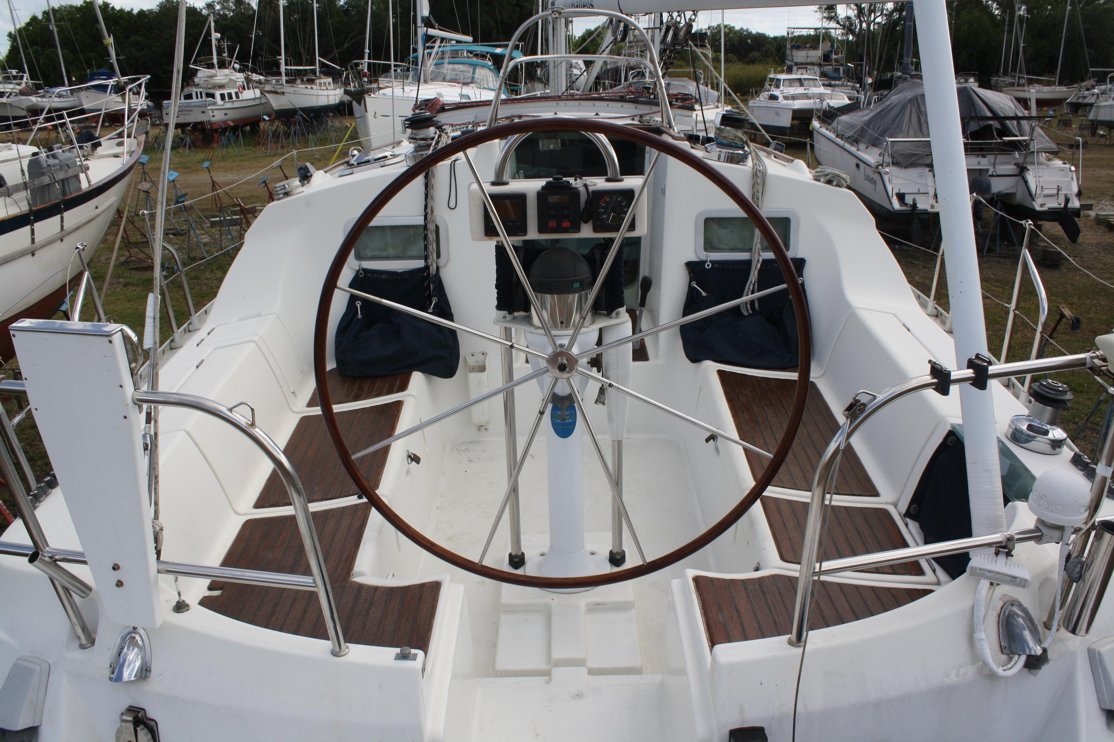 Beautiful Mahogany wheel and teak seats in a large comfortable cockpit