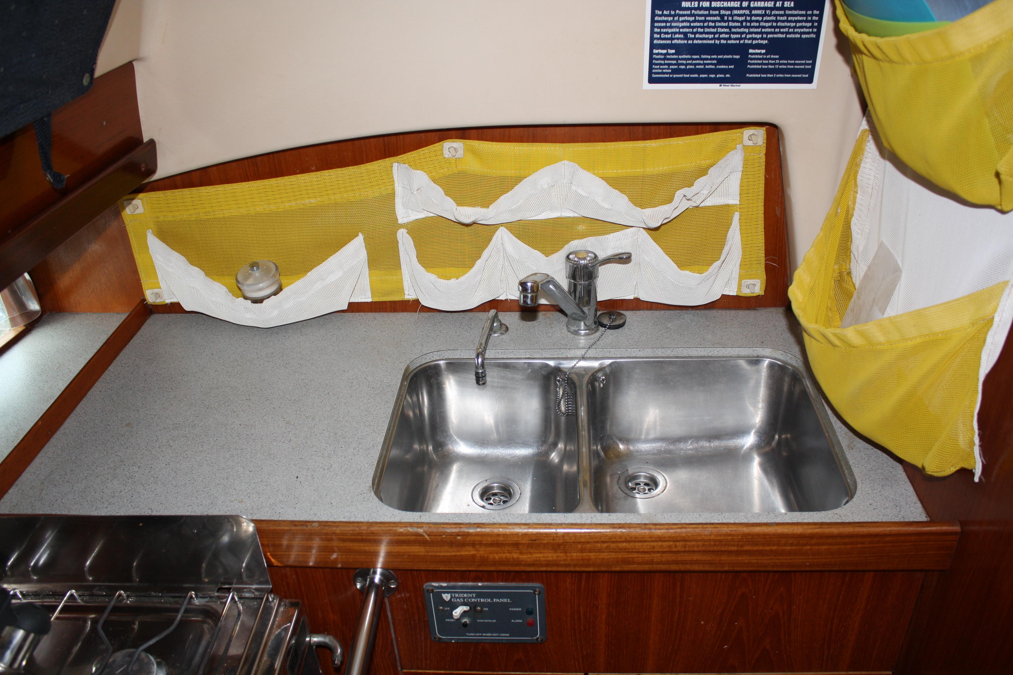 Large double bowl stainless steel sink at aft facing portion of the galley. The owners added many functional organizers in the galley area.
