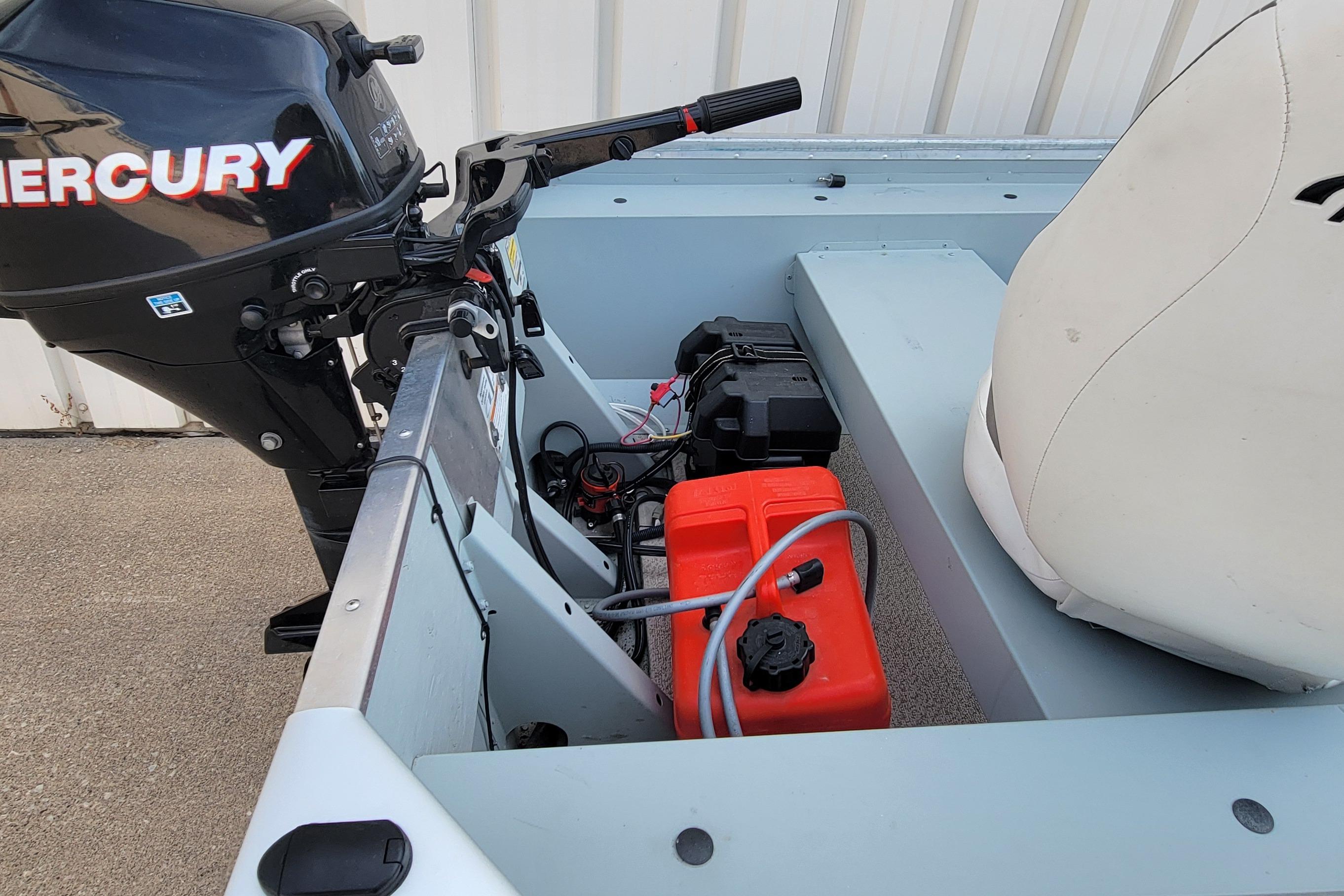 2014 MirroCraft 1400 boat interior with Mercury outboard motor and red fuel tank.
