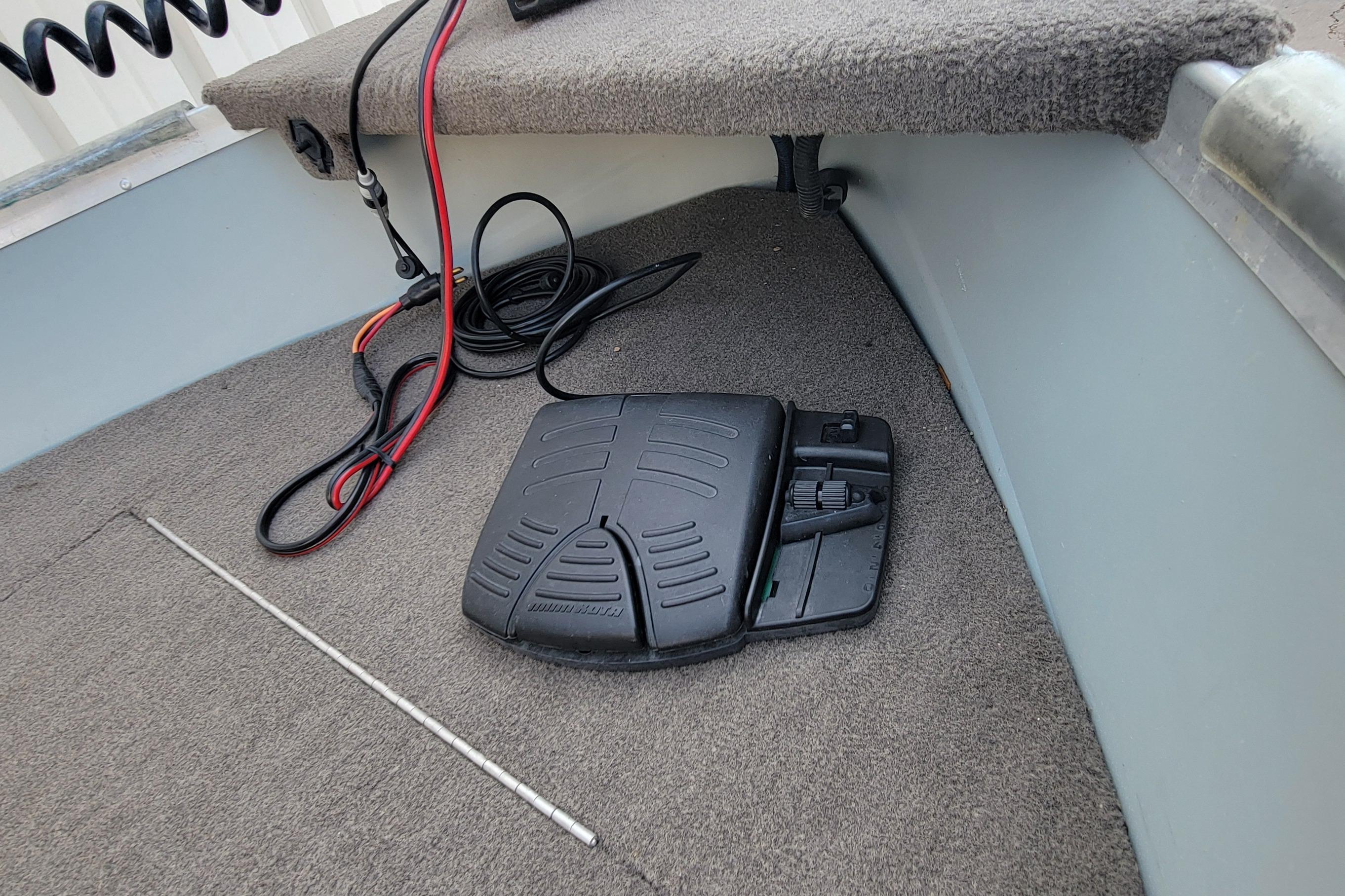 Foot pedal and cables on a 2014 MirroCraft 1400 boat's carpeted floor.