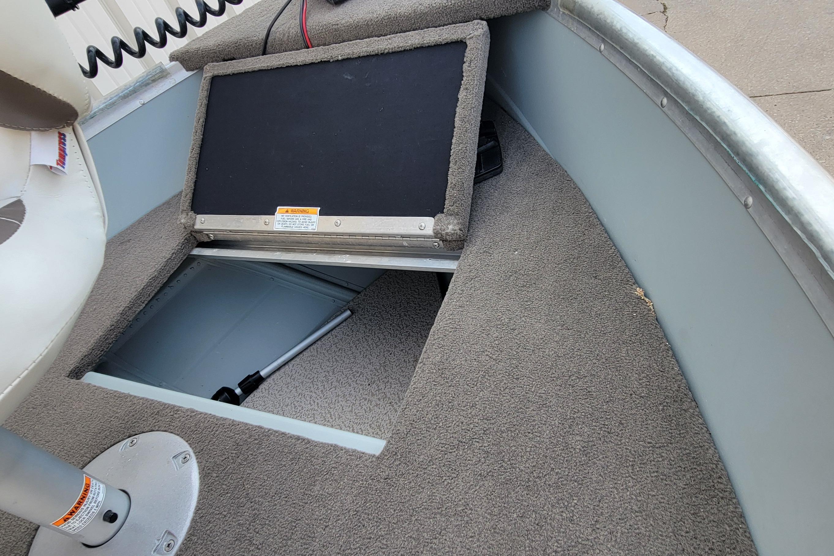 2014 MirroCraft 1400 boat interior with open storage compartment and carpeted floor.