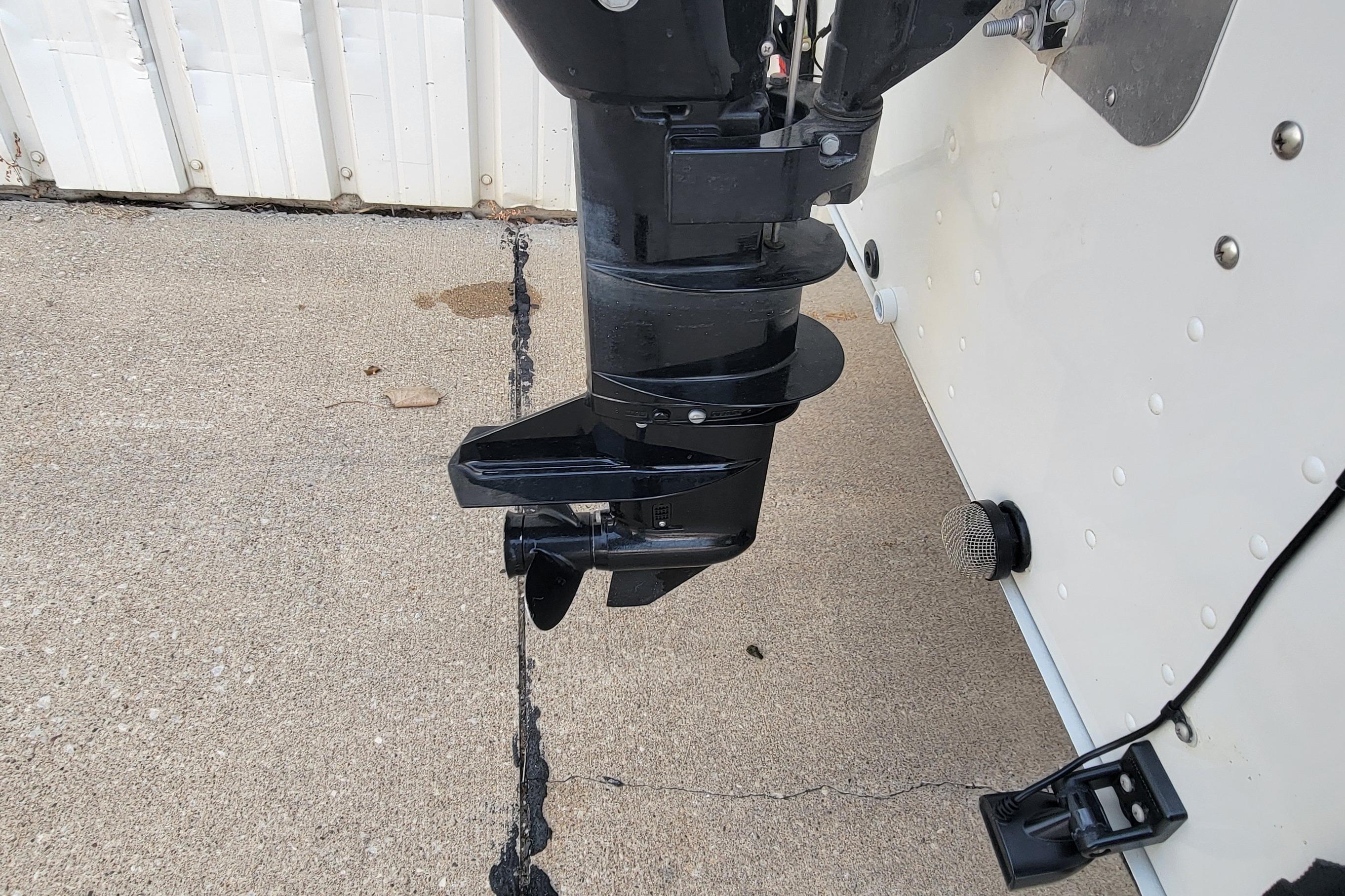 Outboard motor of a 2014 MirroCraft 1400 boat on concrete surface.