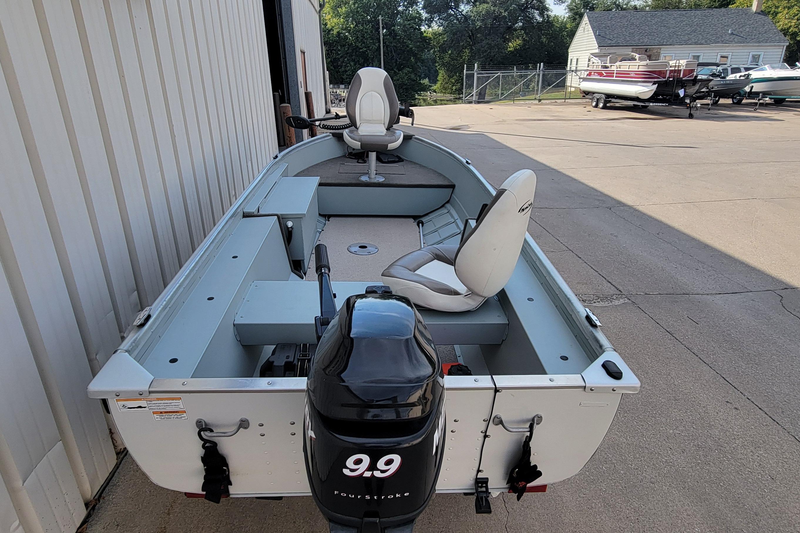 2014 MirroCraft 1400 boat with 9.9 horsepower motor, parked outdoors.