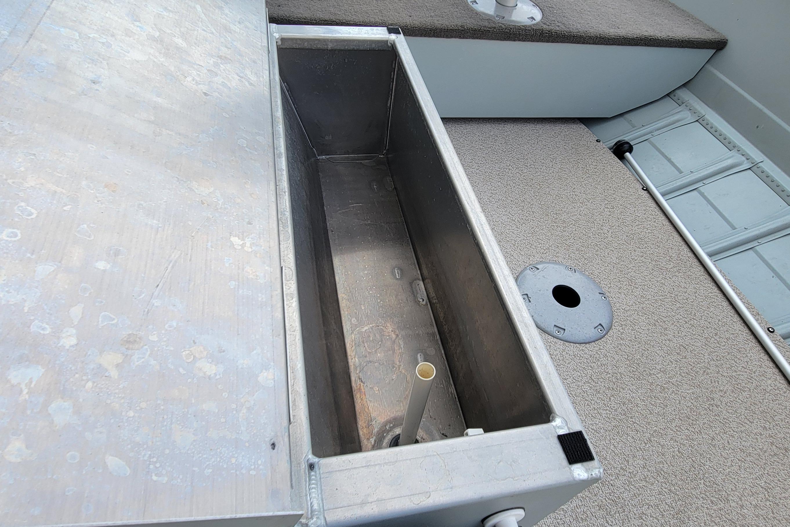 2014 MirroCraft 1400 boat interior showing storage compartment and deck details.