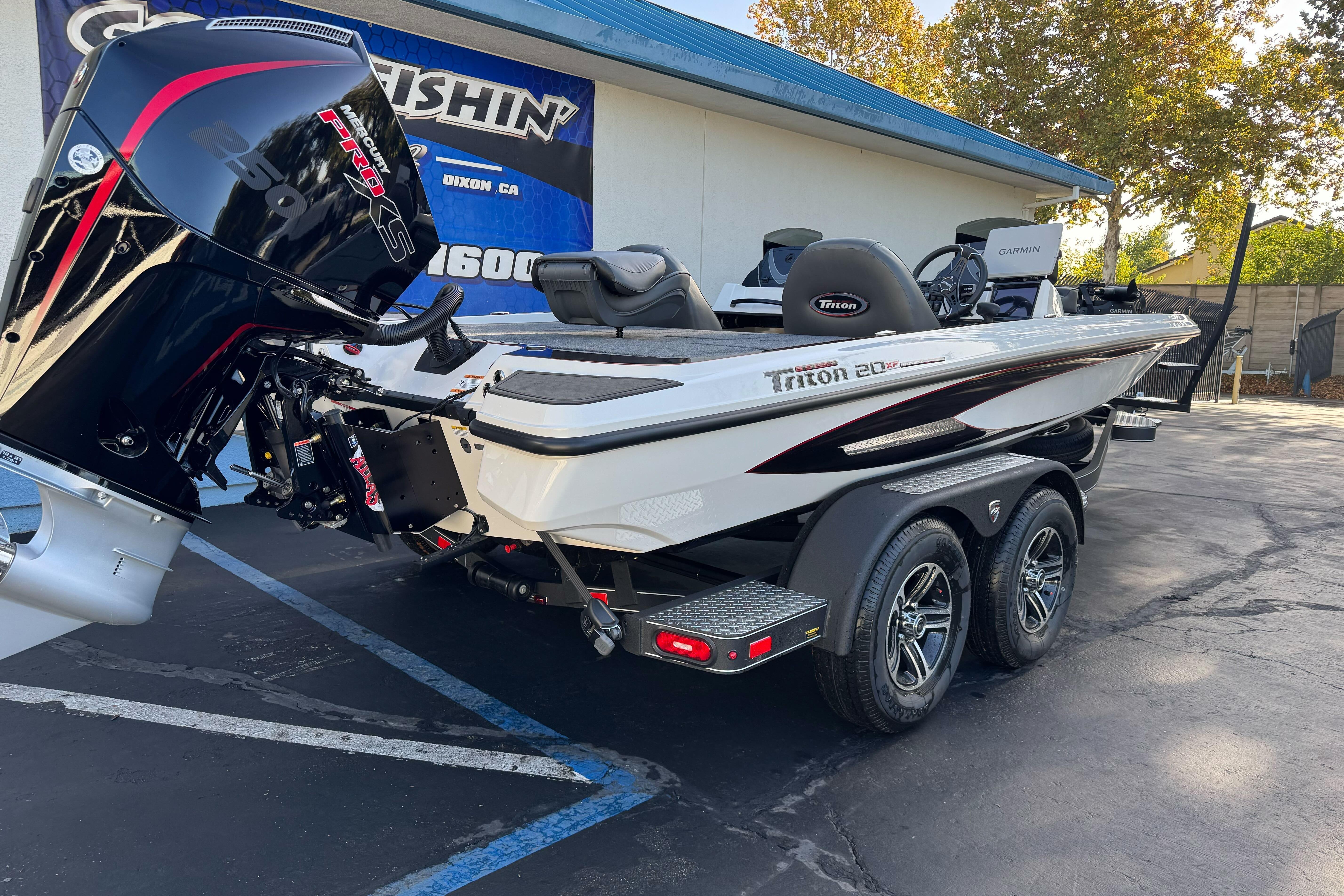 2026 Triton 20XP Patriot boat with powerful outboard motor, parked on a trailer.