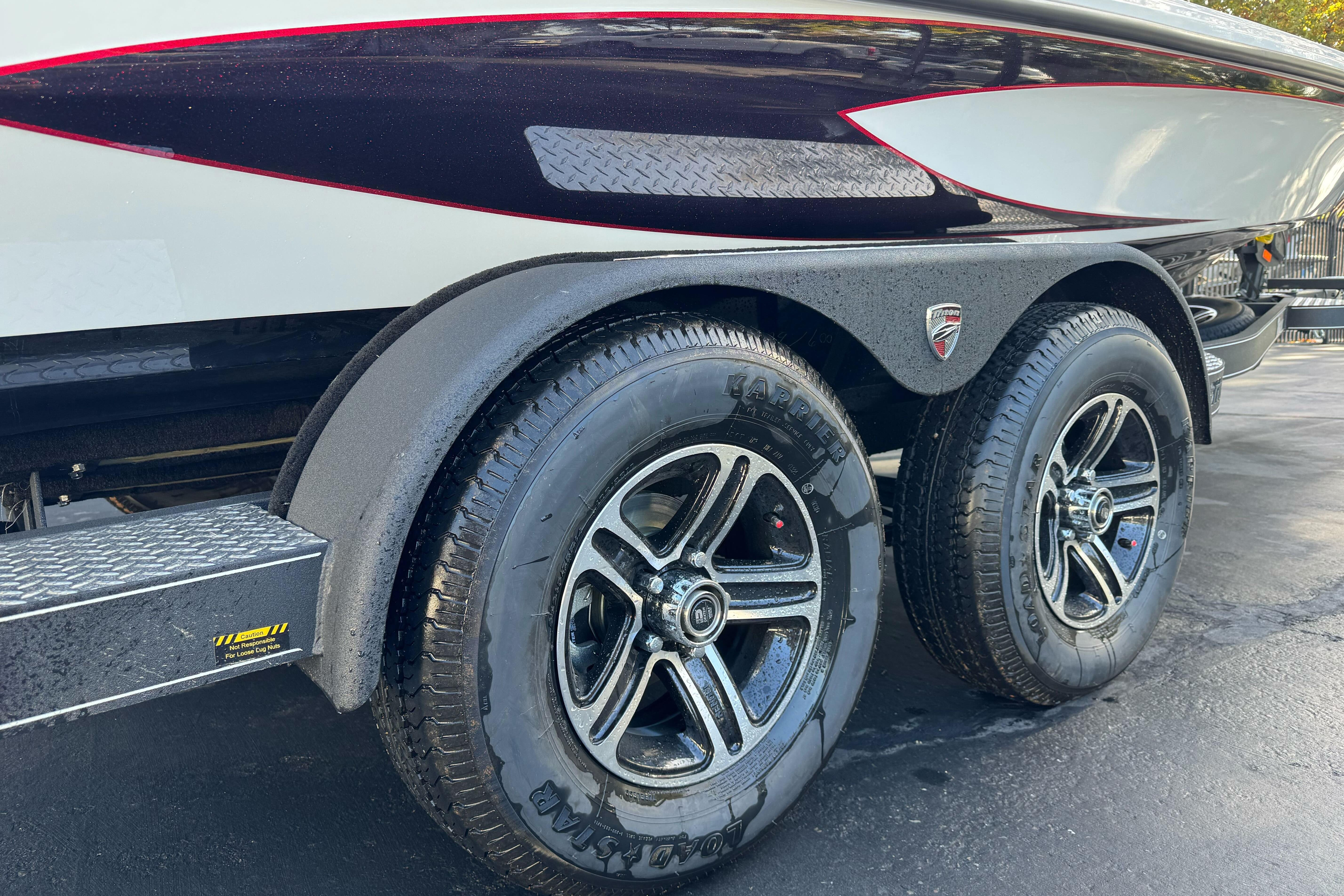 Trailer wheels of a 2026 Triton 20XP Patriot boat, featuring sleek design and durable tires.