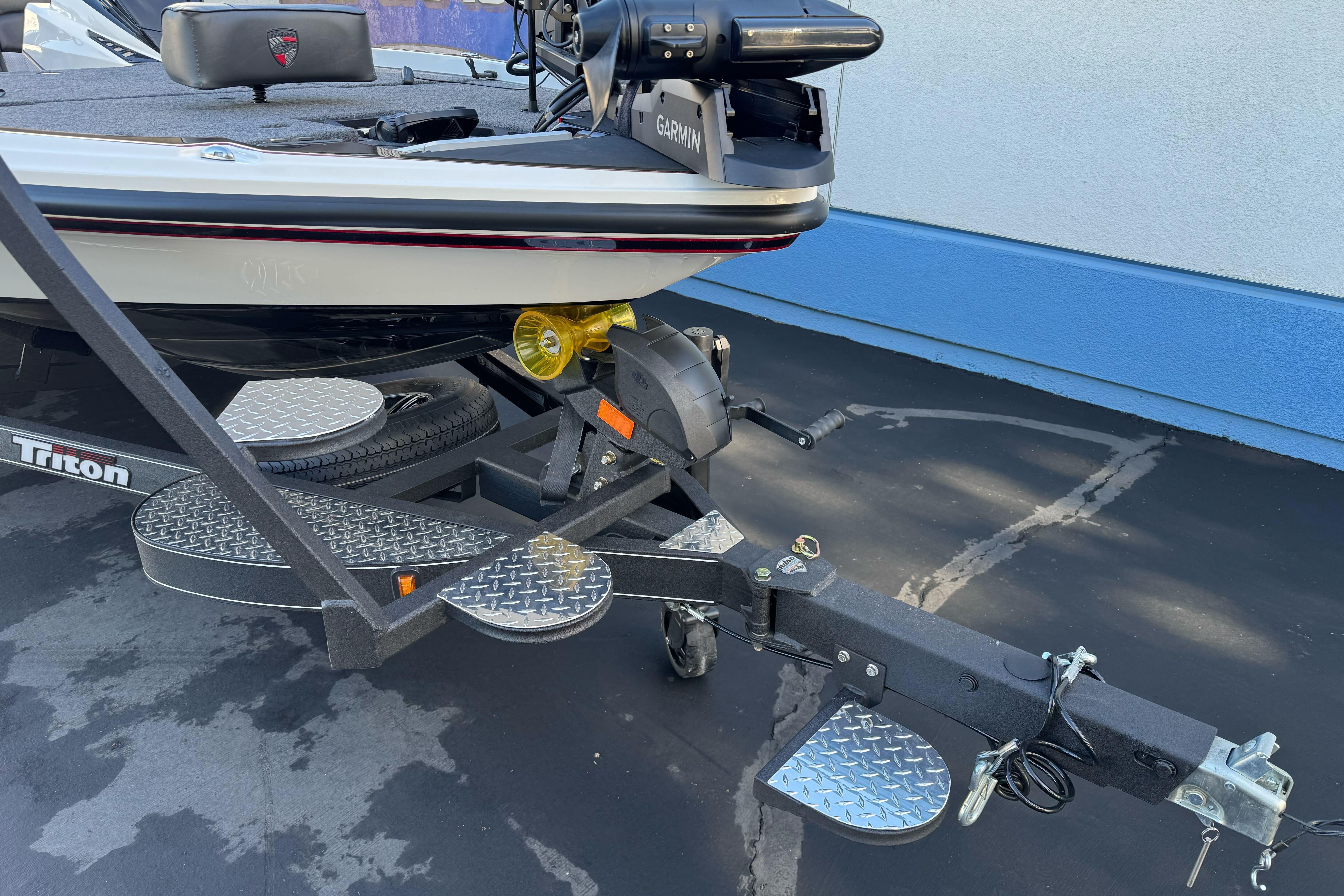 2026 Triton 20XP Patriot boat on trailer with Garmin equipment, parked on pavement.