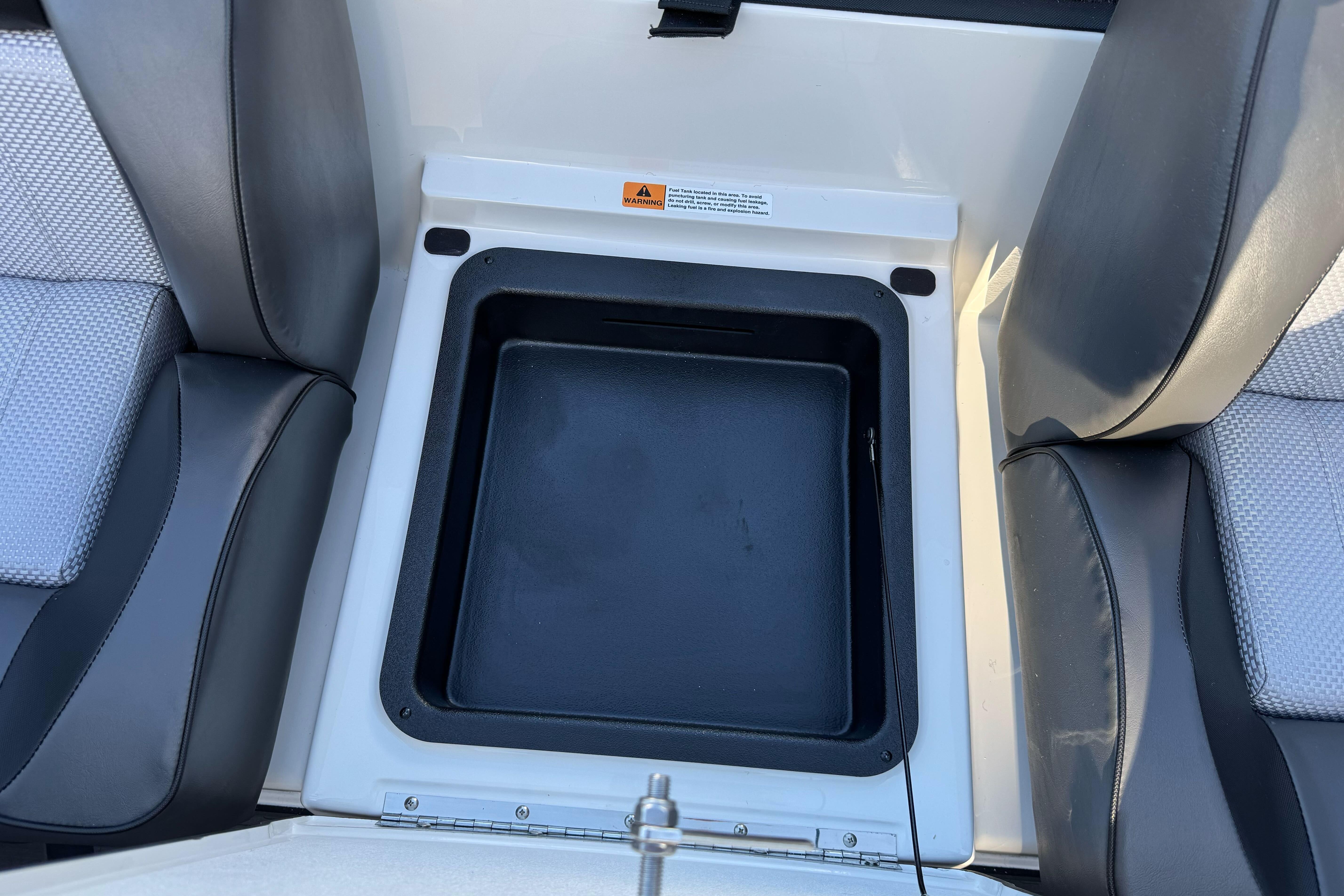 2026 Triton 20XP Patriot boat storage compartment between seats.