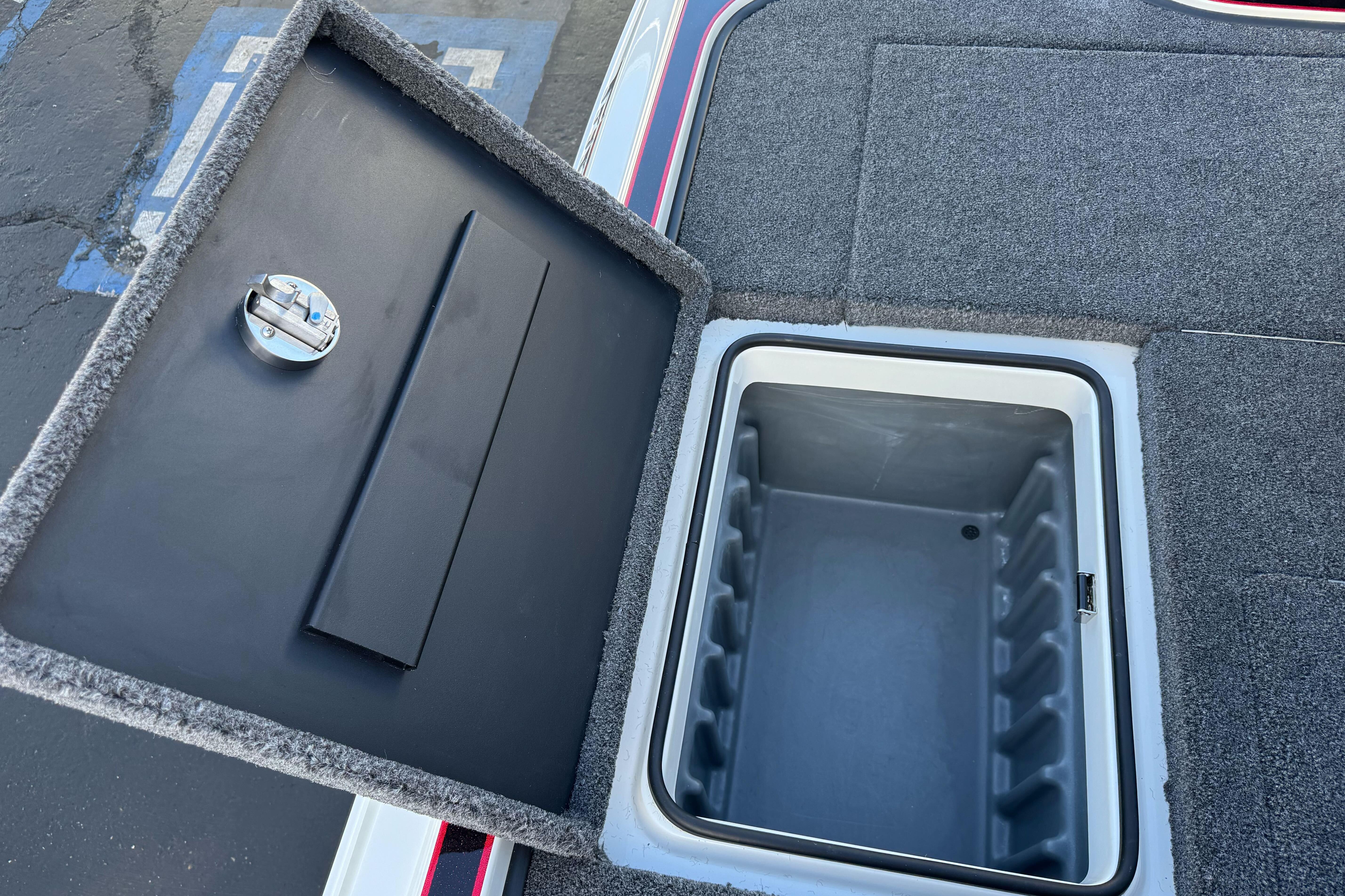 Open storage compartment in 2026 Triton 20XP Patriot boat, featuring carpeted lid and secure latch.