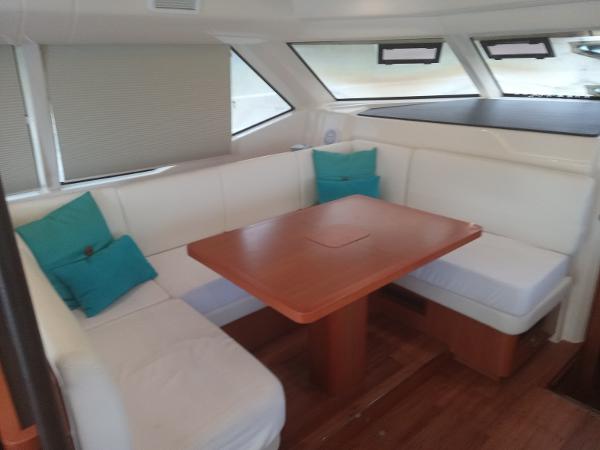 Interior of 2016 Aquila 44 yacht with white seating and wooden table.