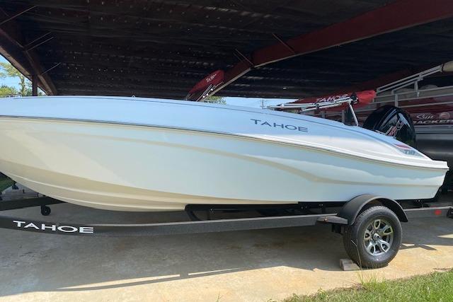 2026 Tahoe T18 boat on trailer under shelter, side view.