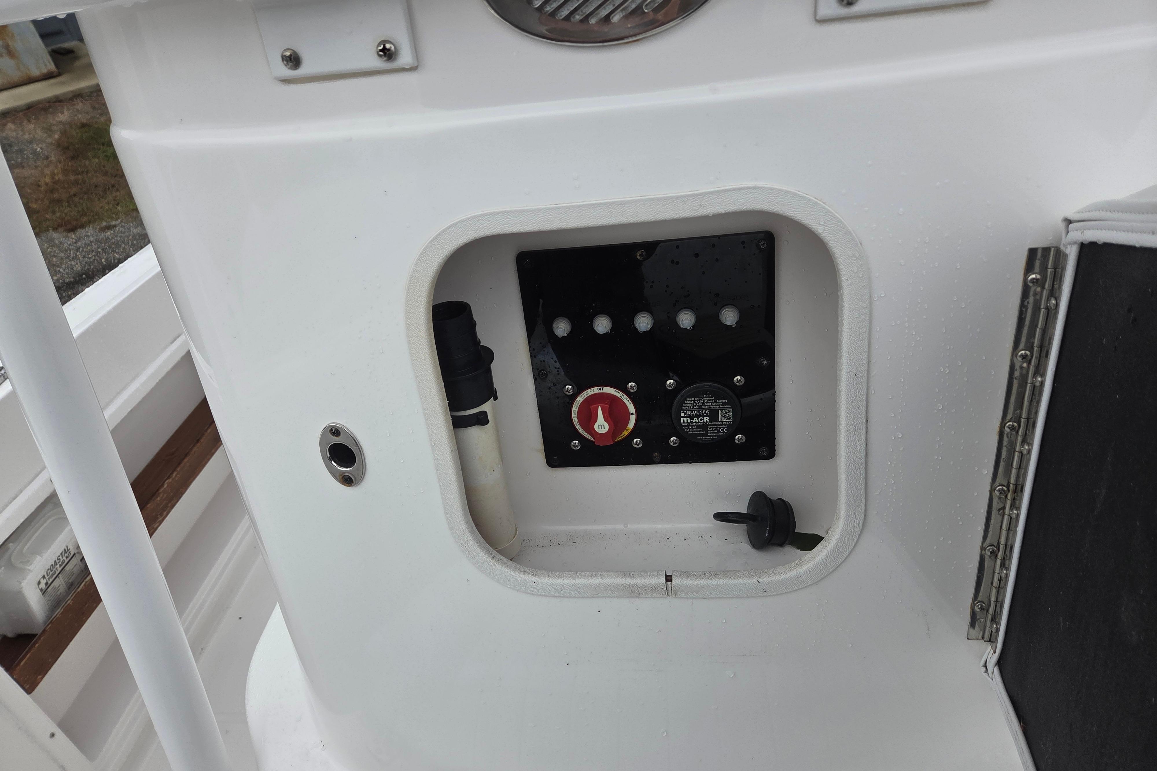 Control panel of a 2022 Limestone L200CC boat, featuring switches and a red knob.