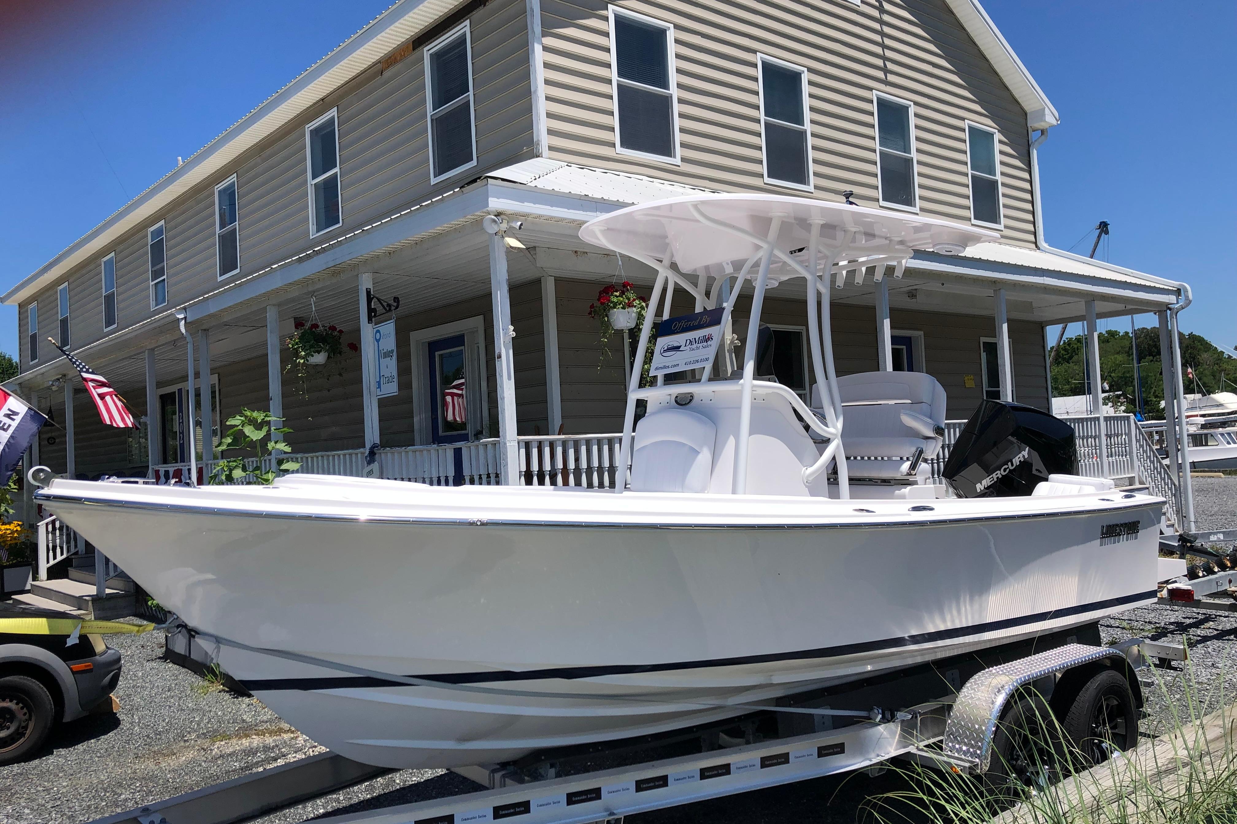 2022 Limestone L200CC boat on trailer outside a building with American flags.