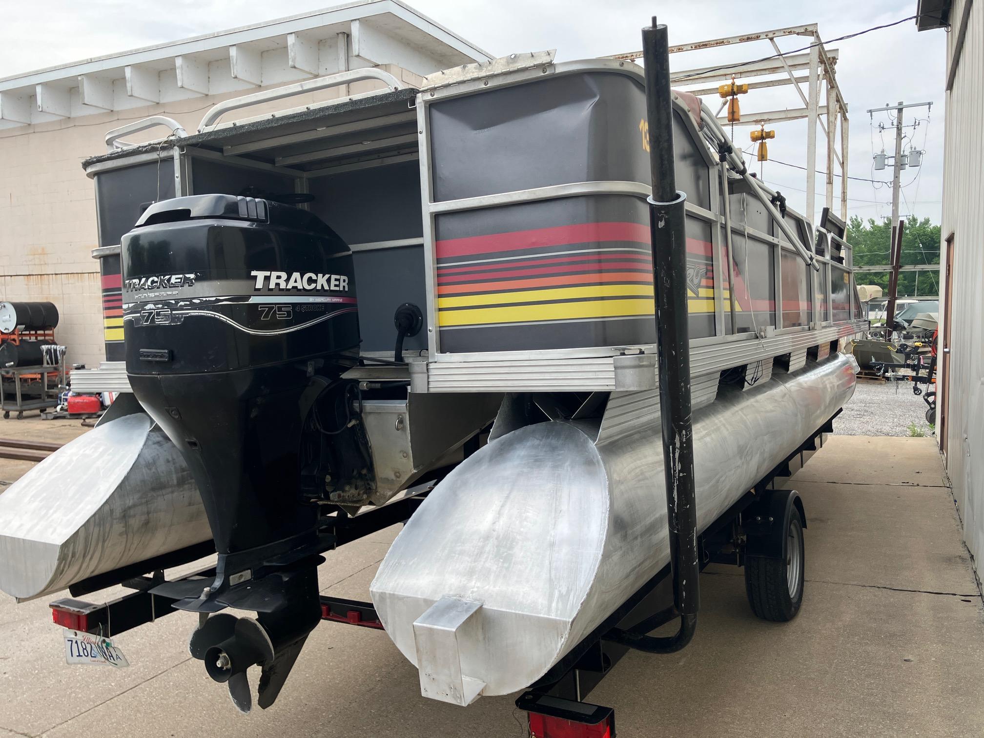 1990 Astro 24' Pontoon boat with Tracker outboard motor, parked on a trailer.