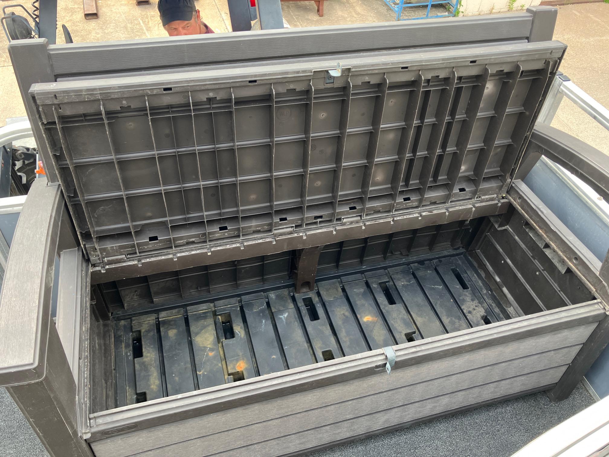 Open storage compartment on a 1990 Astro 24' Pontoon boat, showcasing interior space.