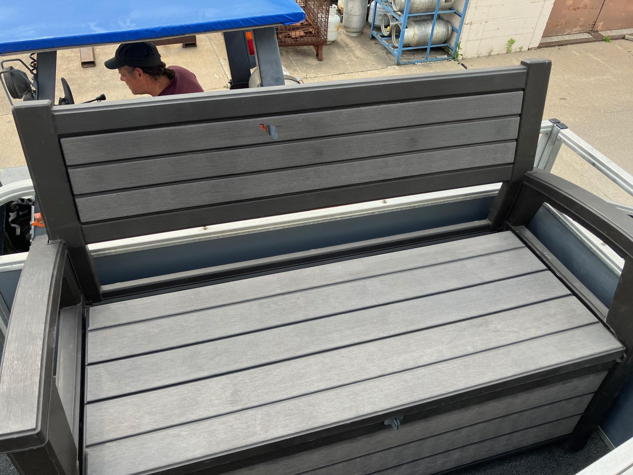 1990 Astro 24' Pontoon with gray wooden bench seating on deck.