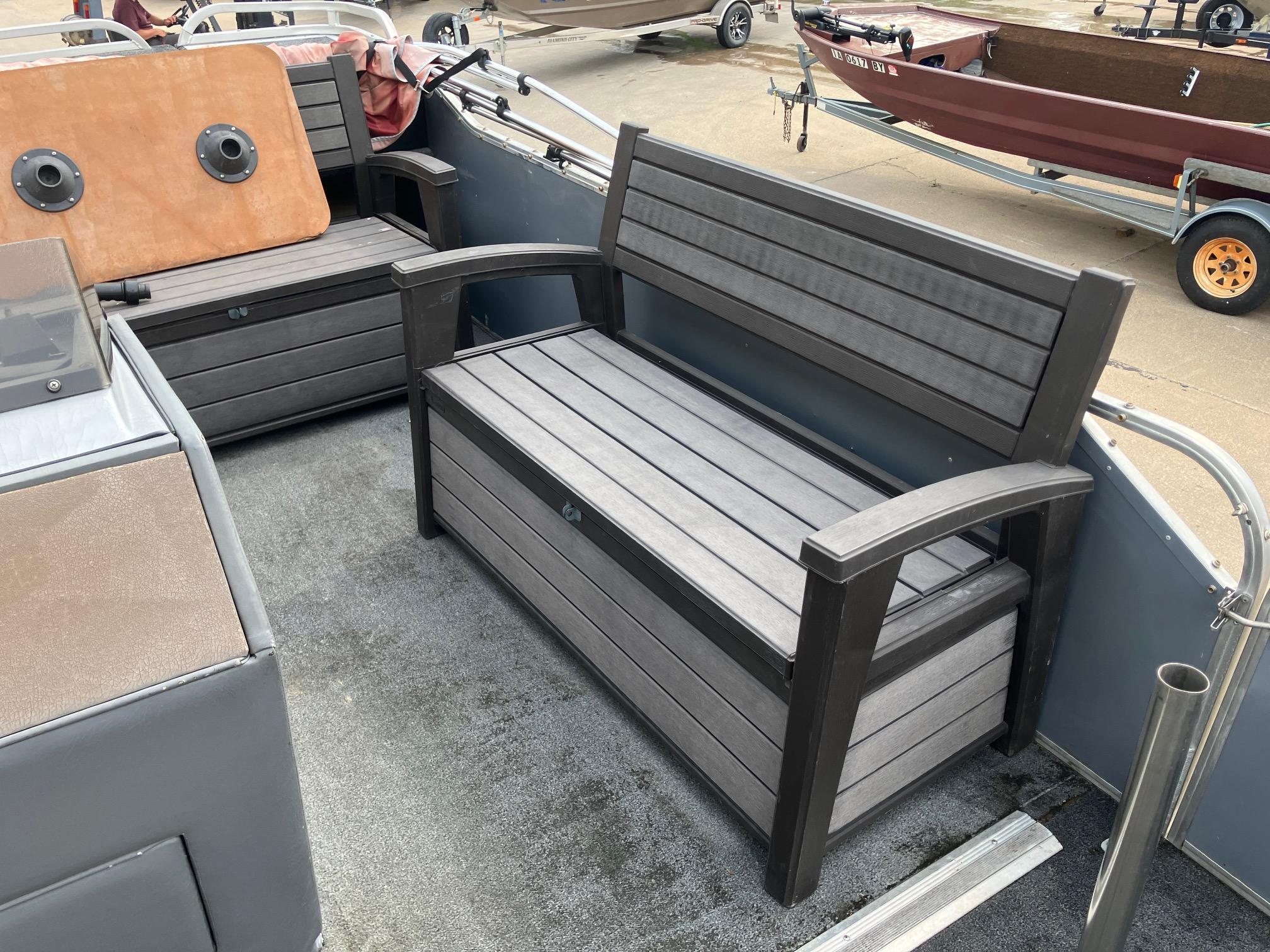 1990 Astro 24' Pontoon boat interior with wooden bench seating and carpeted flooring.