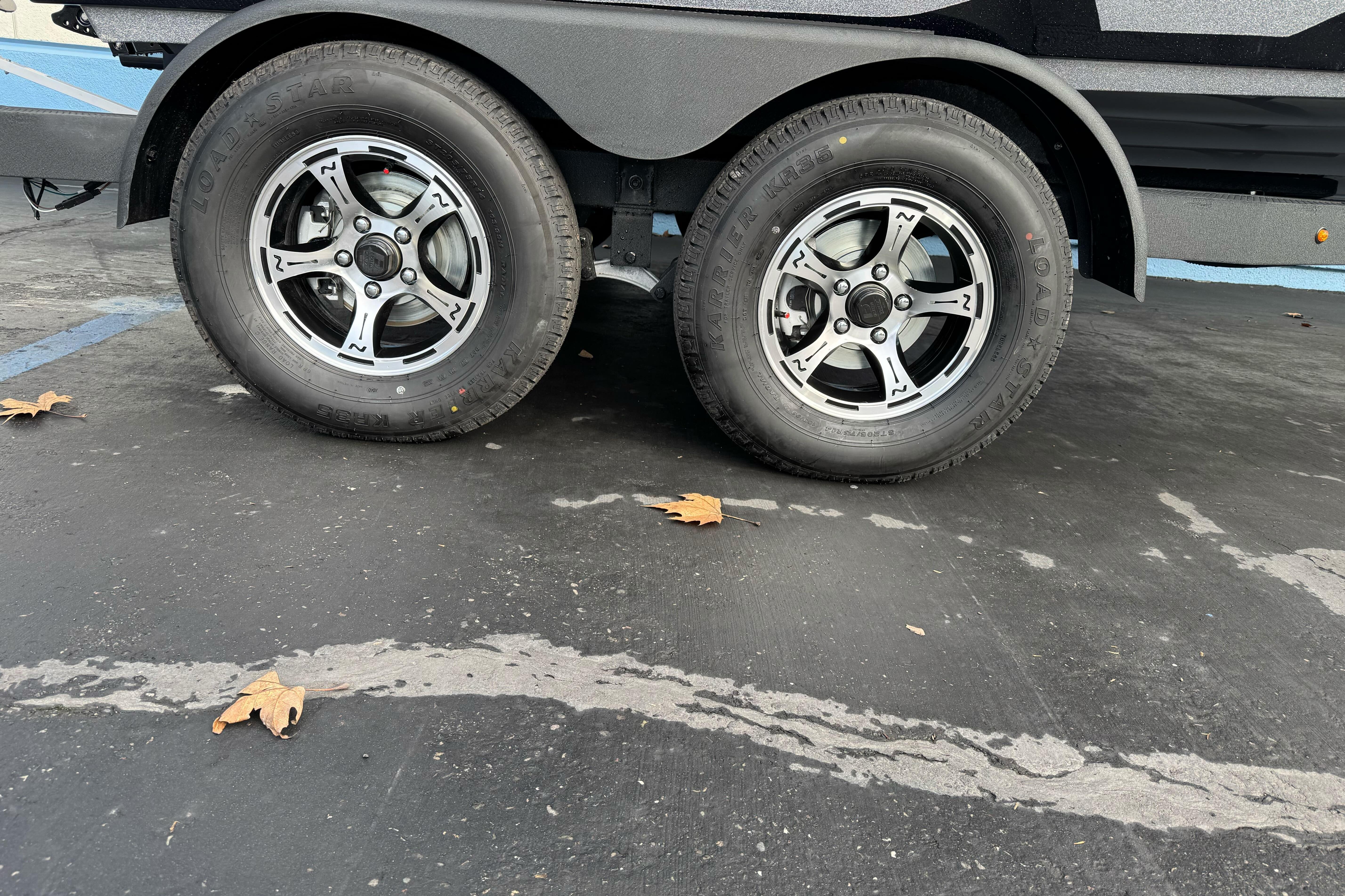 2026 Nitro Z19 XL trailer wheels on asphalt with scattered leaves.