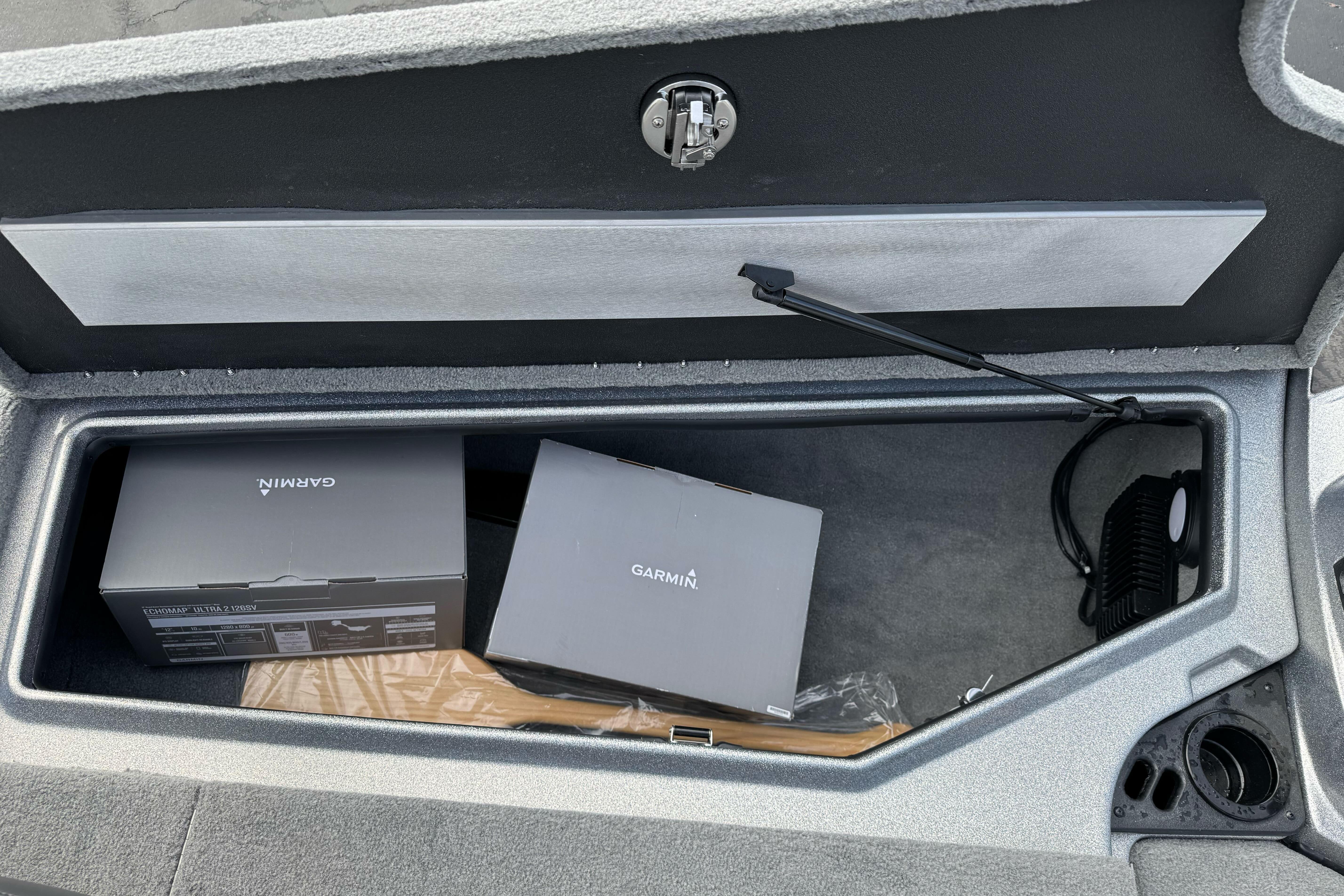 Open storage compartment in 2026 Nitro Z19 XL boat with Garmin boxes inside.