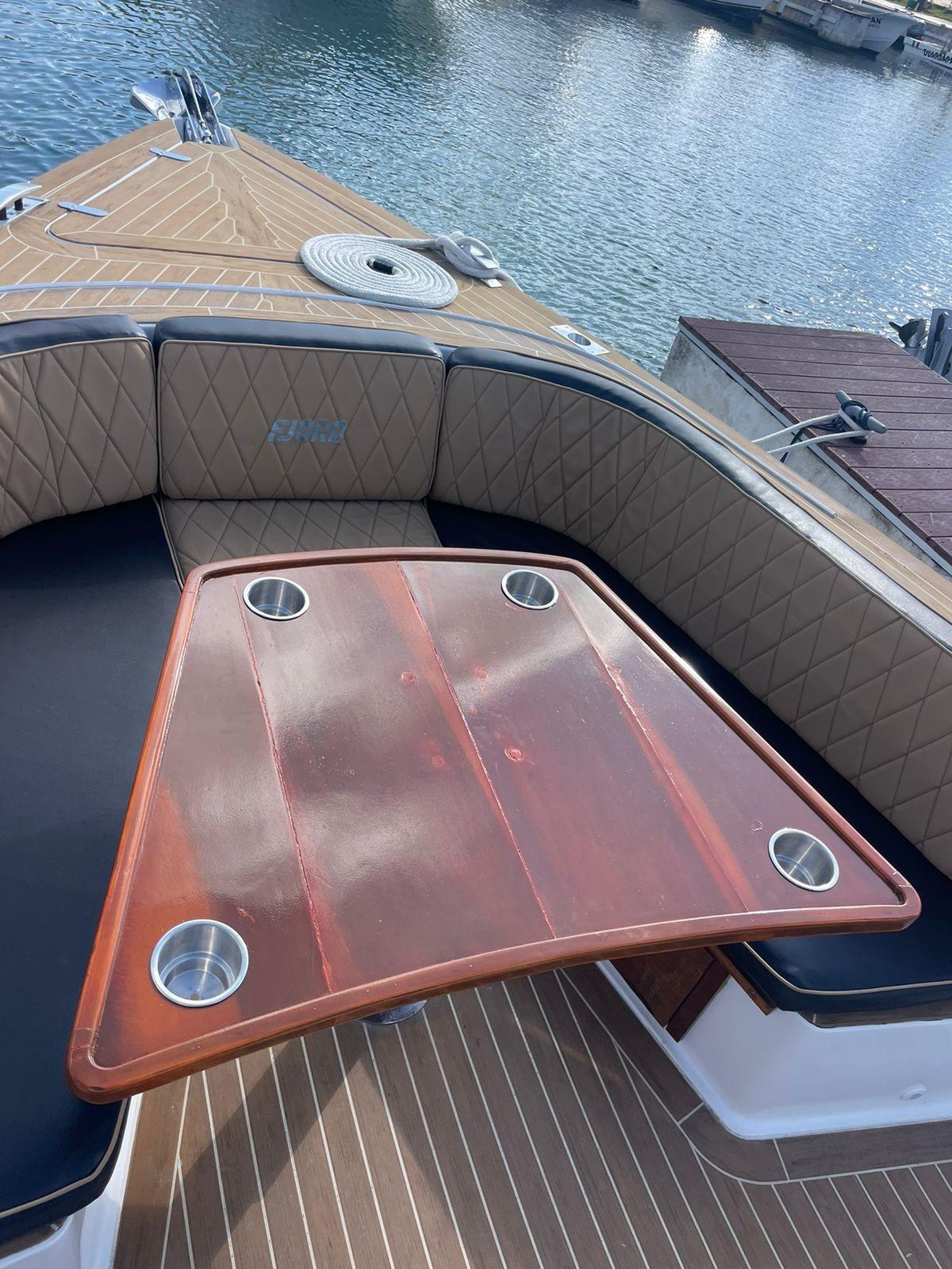 Fjord-36 Open 2018 -FL-US-2018 Fjord 36 Open boat with a wooden table and cushioned seating.-9391029 | Thumbnail