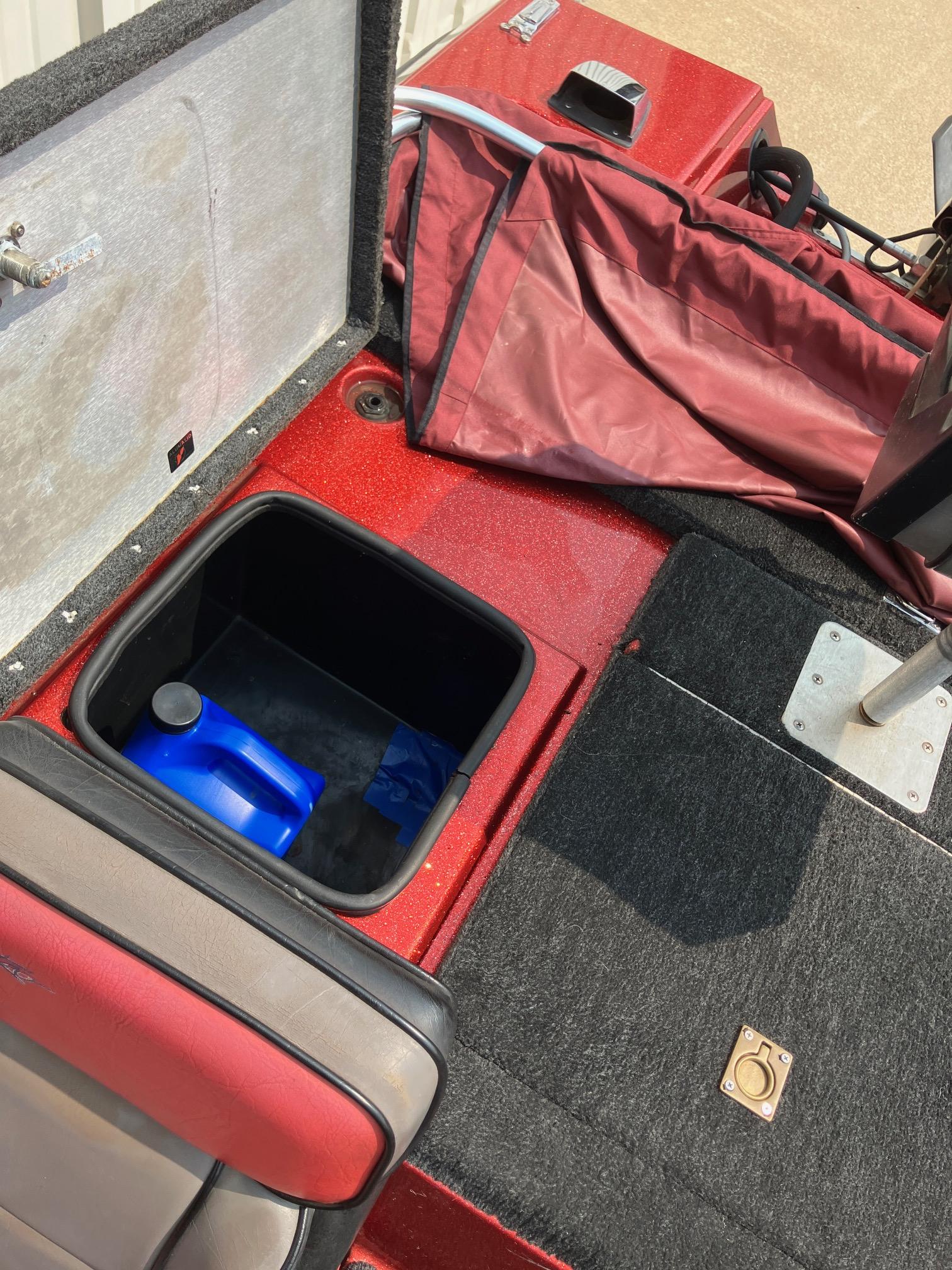 1990 Astro 17 1/2' Bass Boat interior with storage compartment and red upholstery.