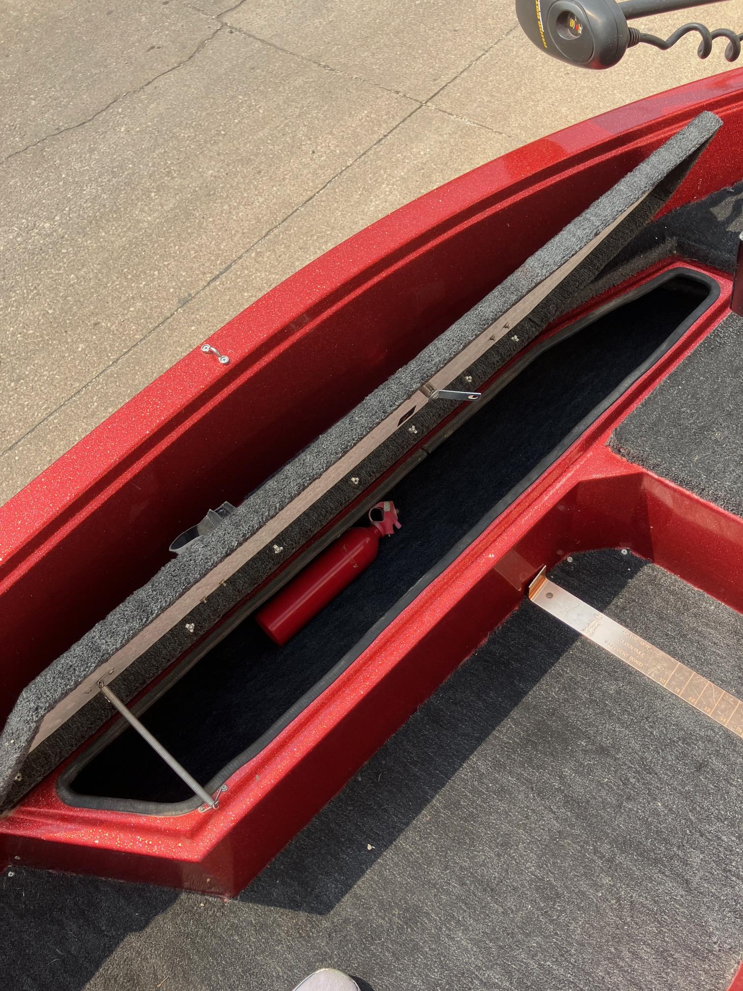 1990 Astro 17 1/2' Bass Boat storage compartment with red interior and fire extinguisher.