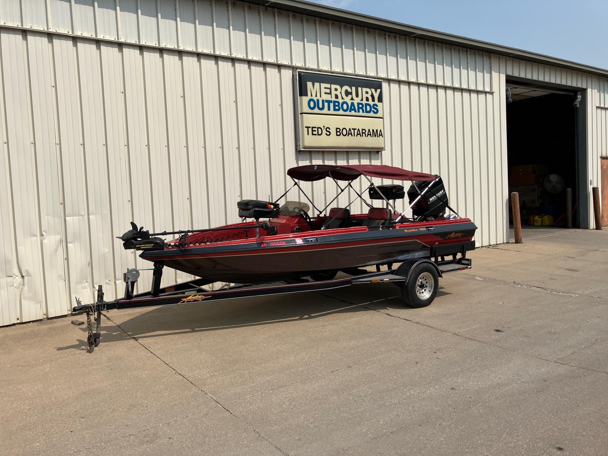 1990 Astro 17 1/2' Bass Boat on trailer outside Mercury Outboards shop.