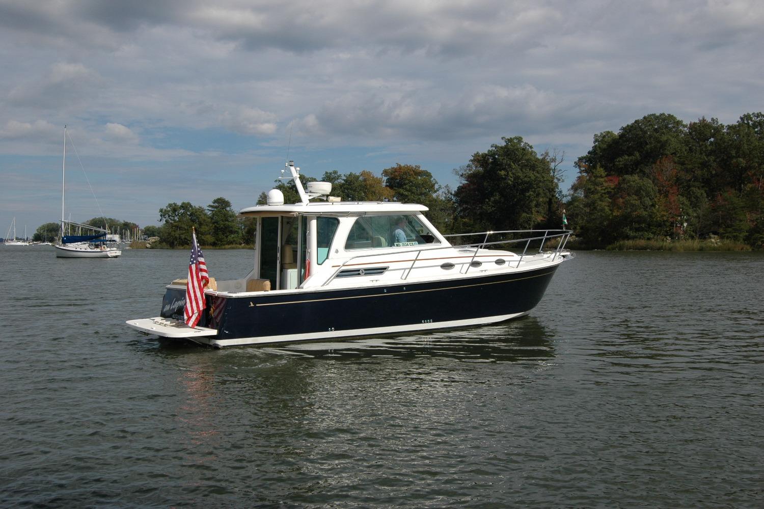 2014 Back Cove 34 boat on calm water with trees in the background.
