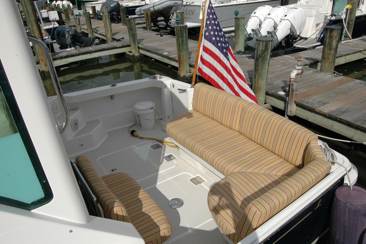 2014 Back Cove 34 boat with striped seating and American flag at dock.