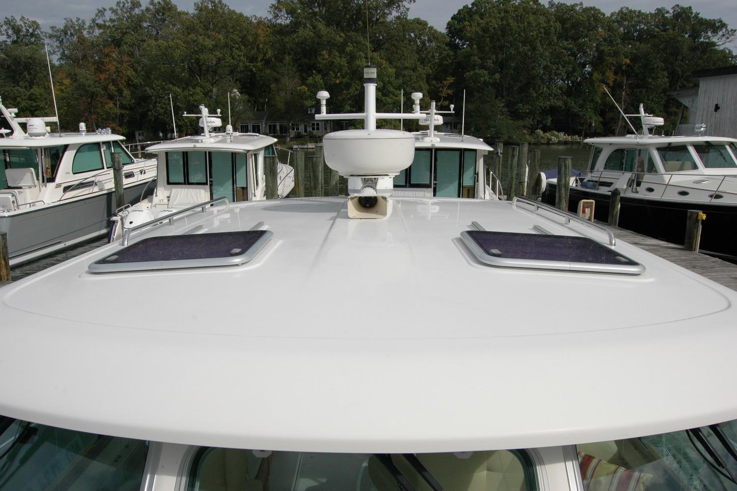 2014 Back Cove 34 boat docked, featuring a sleek white roof and hatches.