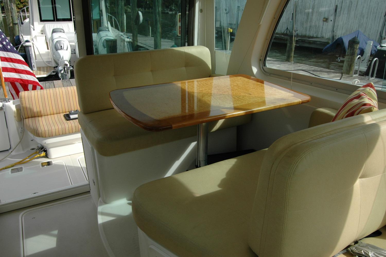 Interior of 2014 Back Cove 34 boat with seating and wooden table.